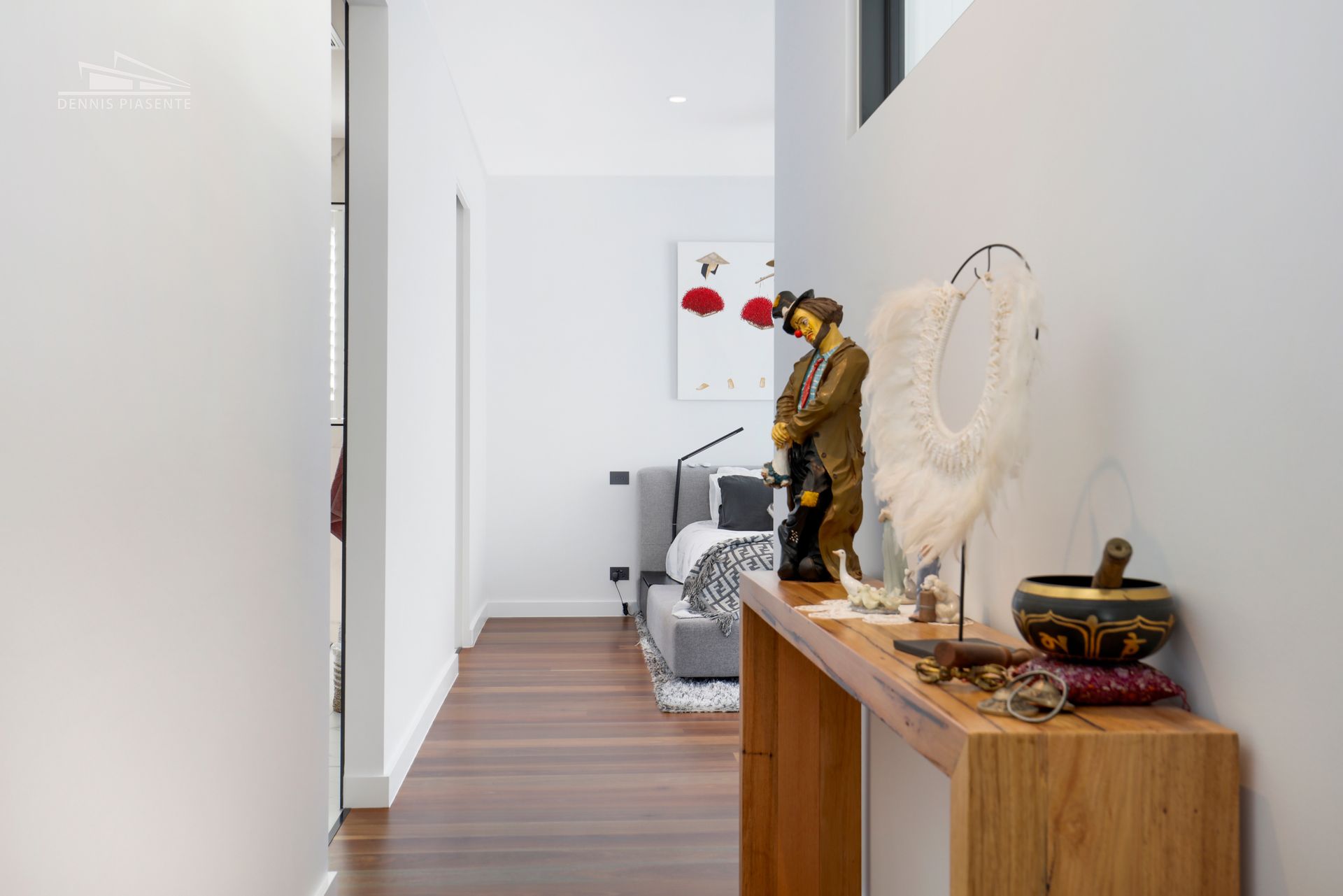 A hallway with a wooden table and a statue on the wall.