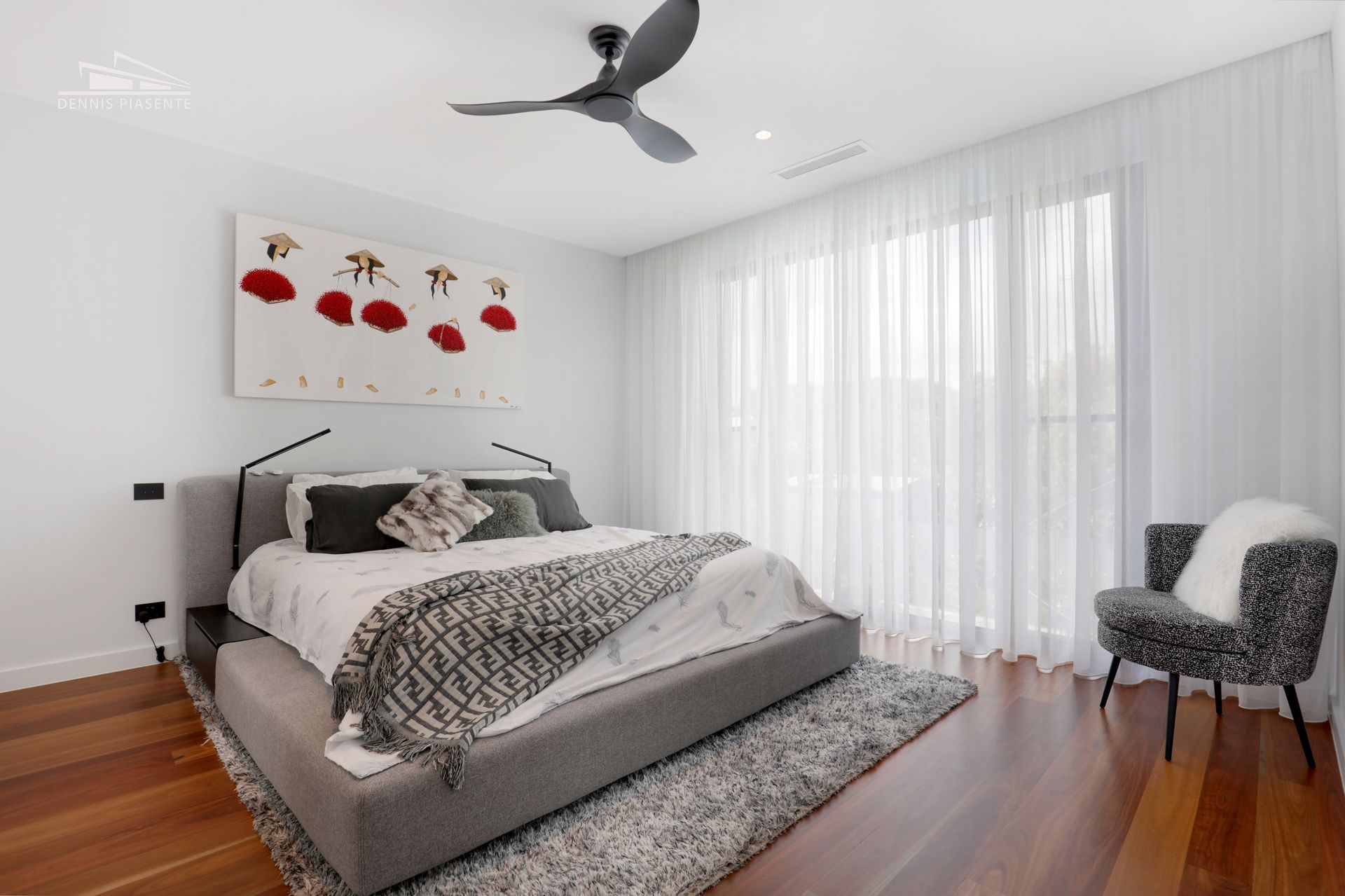A bedroom with a large bed and a ceiling fan