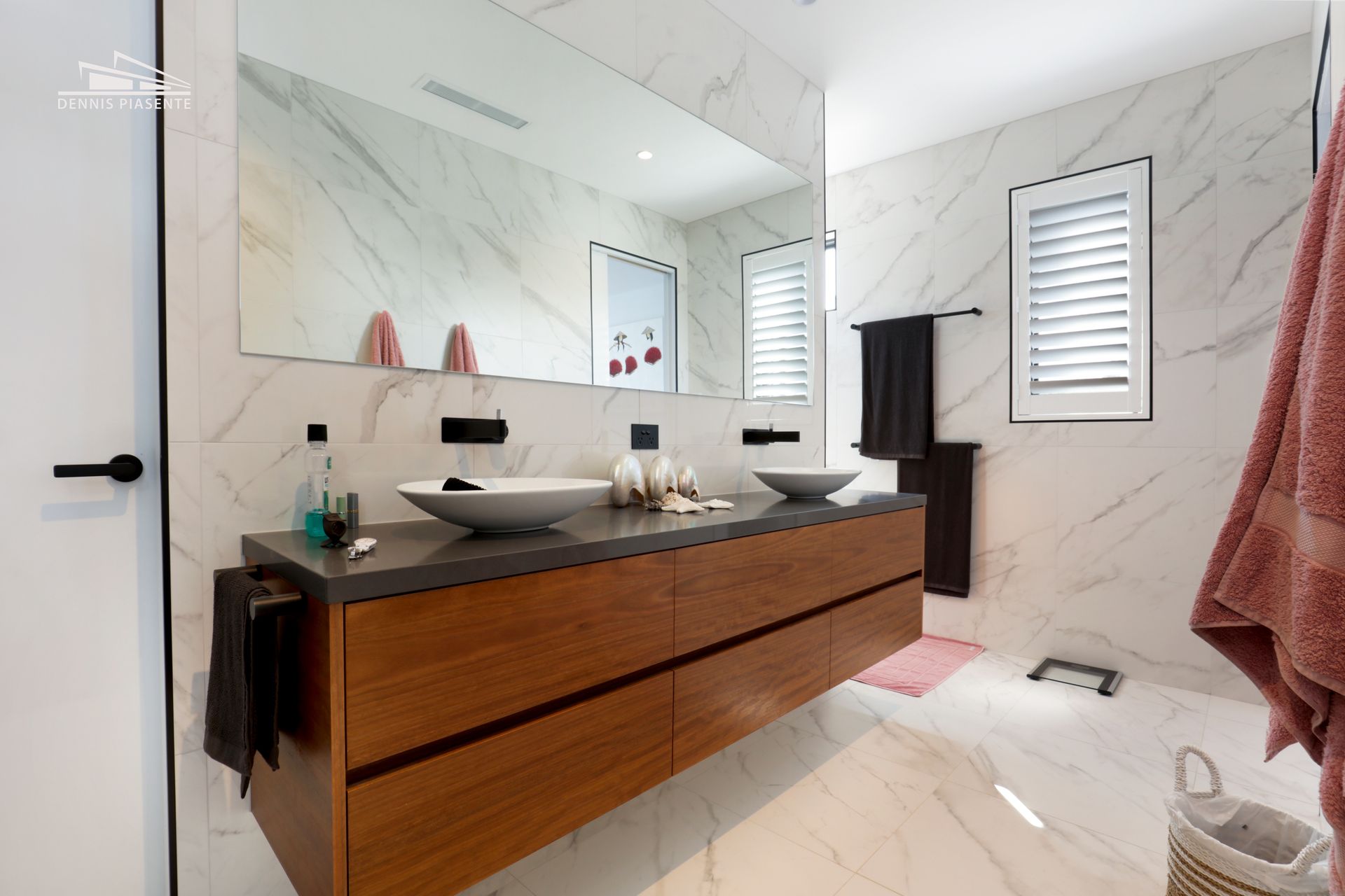 A bathroom with two sinks and a large mirror.
