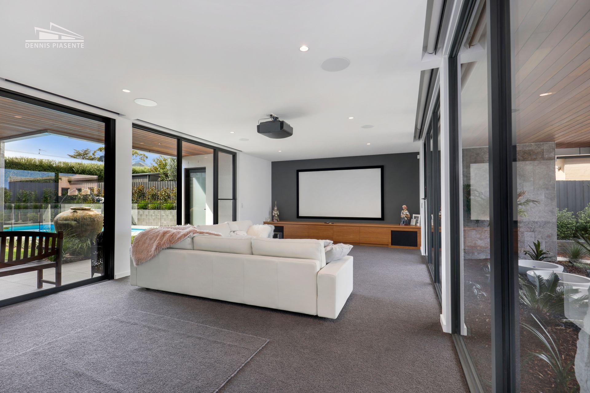 A living room with a couch and a projector screen.