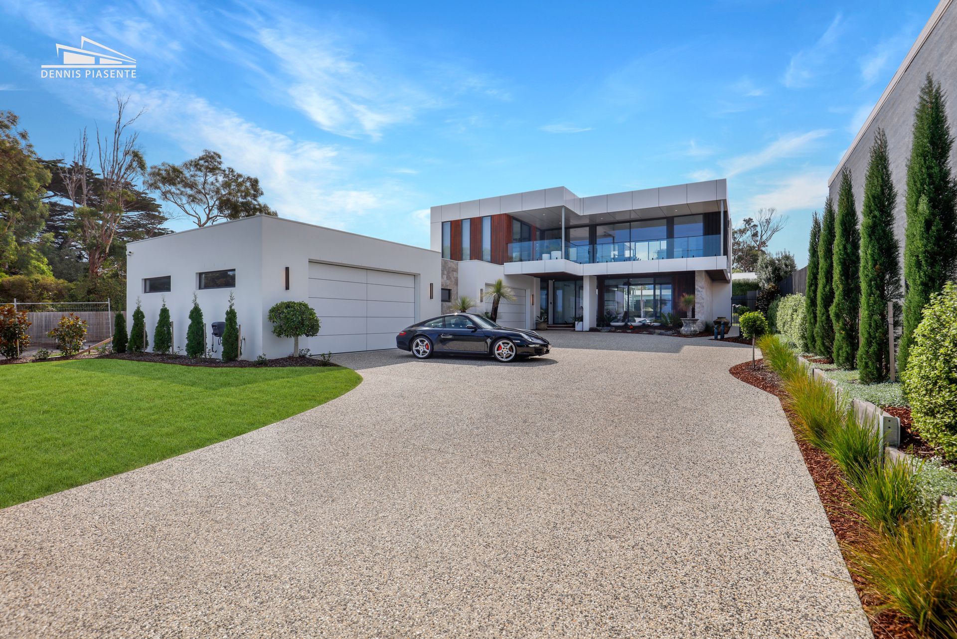 A car is parked in front of a large white house