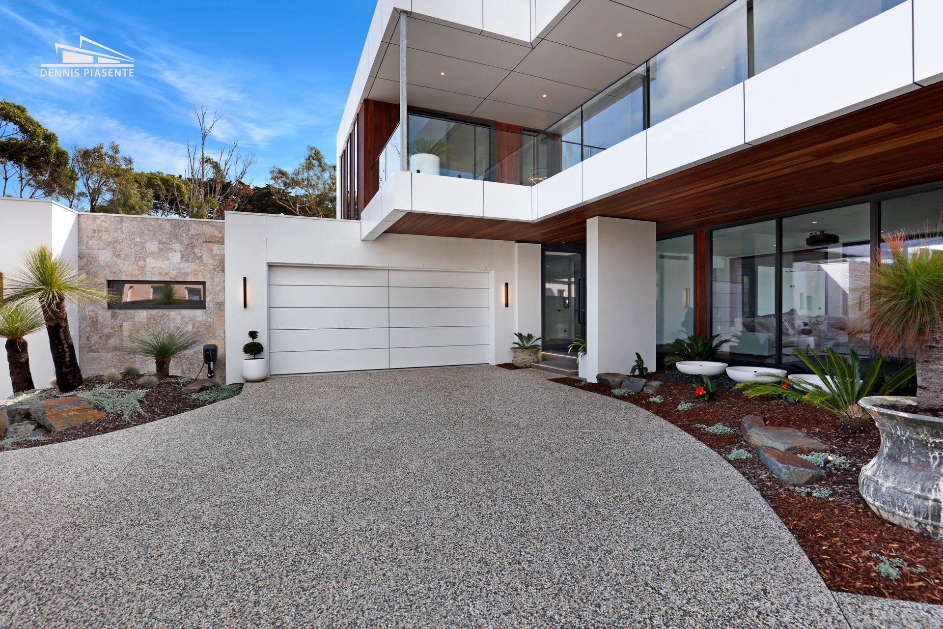 A large house with a white garage door and a driveway leading to it.