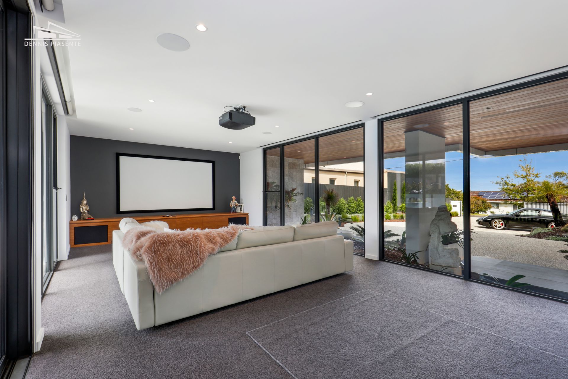 A living room with a couch and a projector screen.