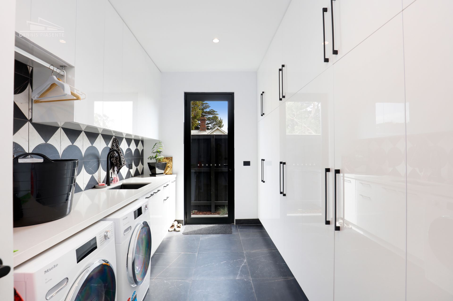A laundry room with a washer and dryer and a sink.