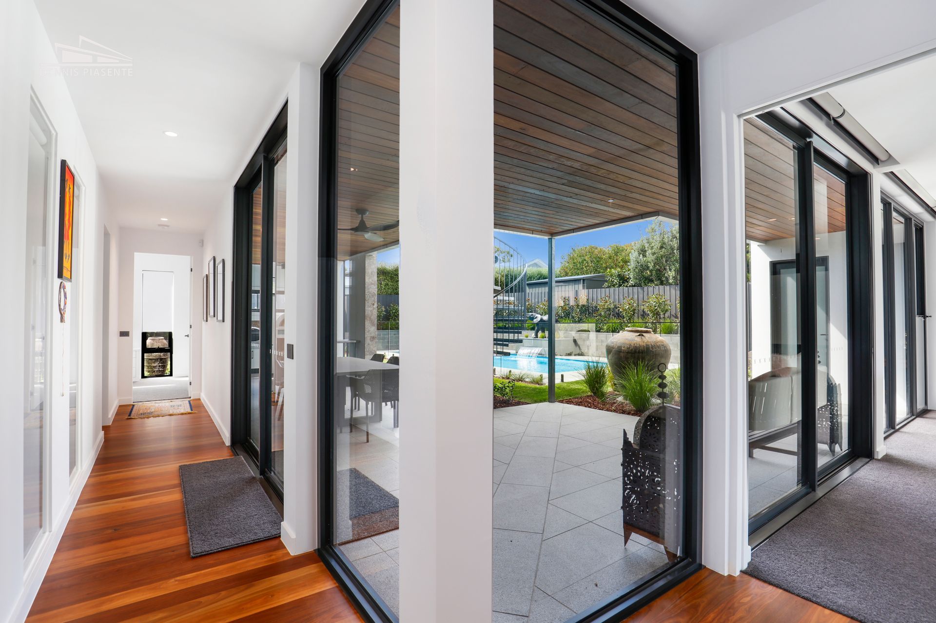 A hallway with sliding glass doors leading to a patio and a pool.