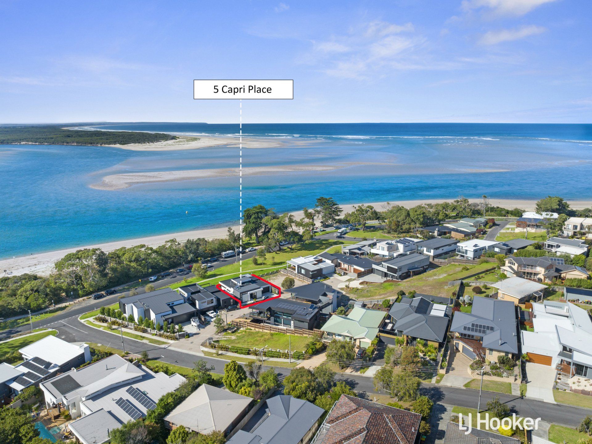 An aerial view of a house next to a body of water.