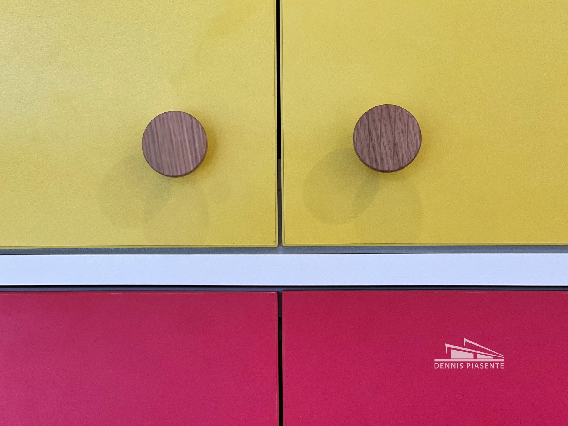 A yellow and red cabinet with wooden handles