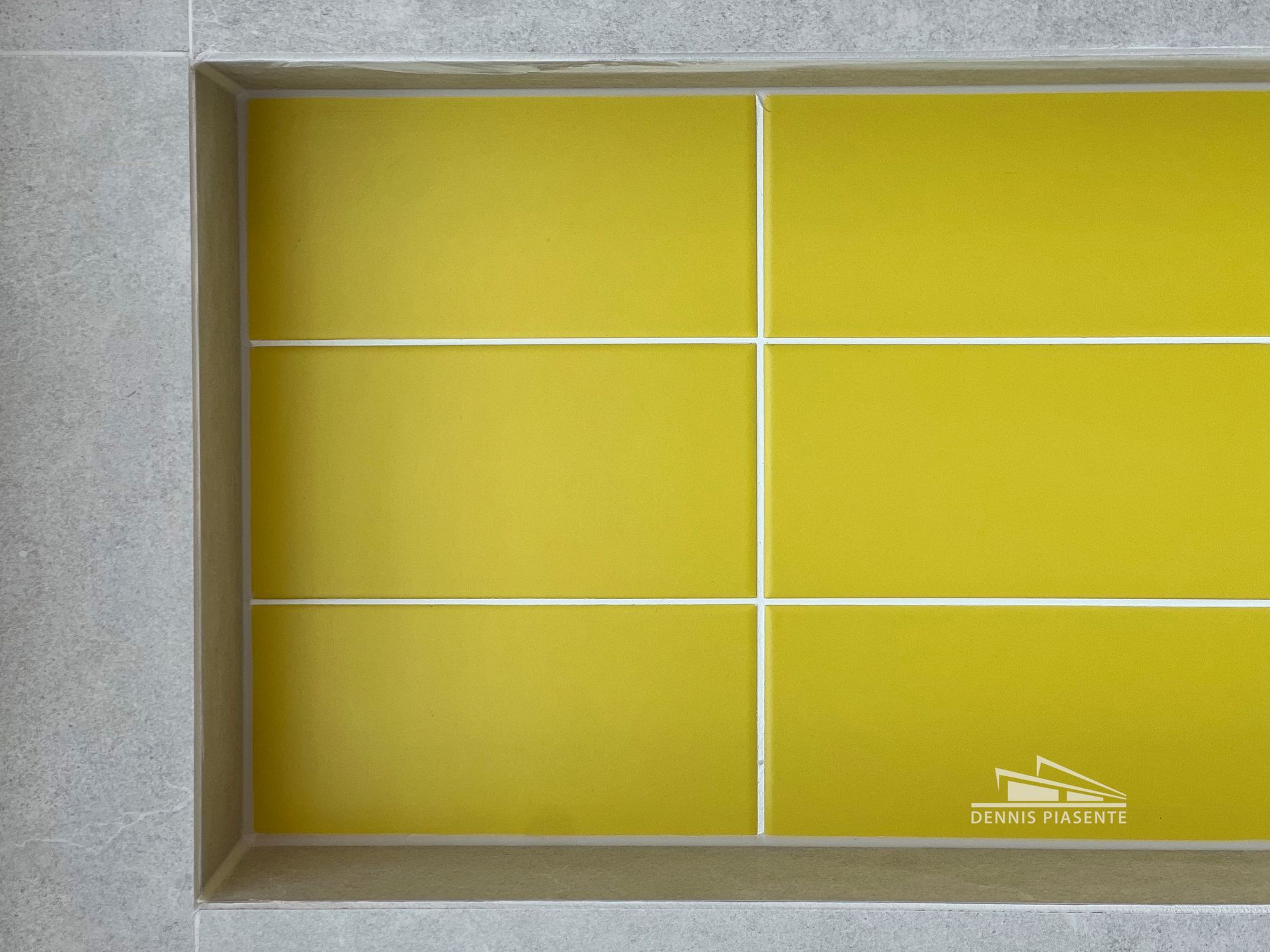 Yellow tiles on a gray wall with a white border