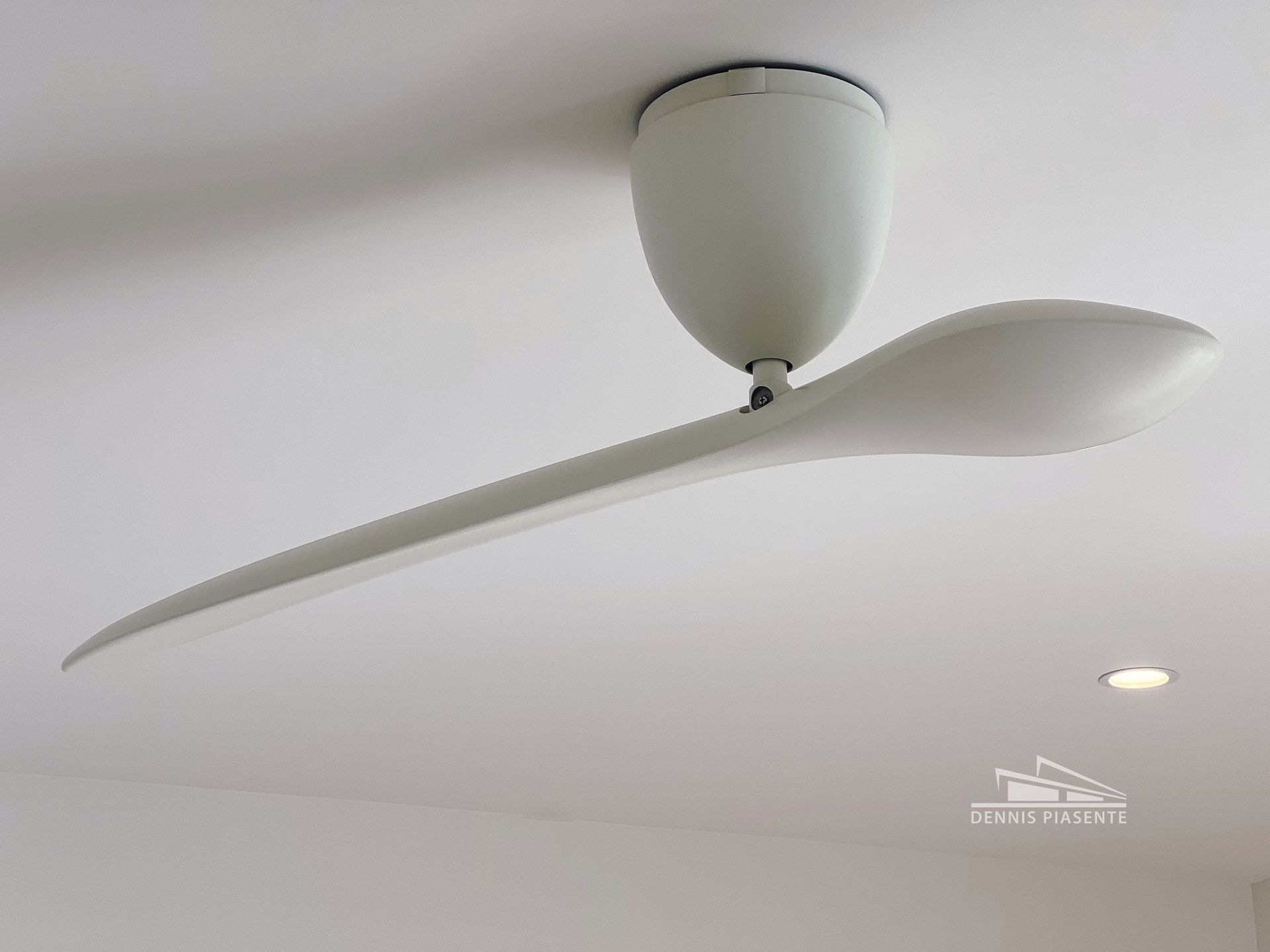 A white ceiling fan is hanging from the ceiling in a room.