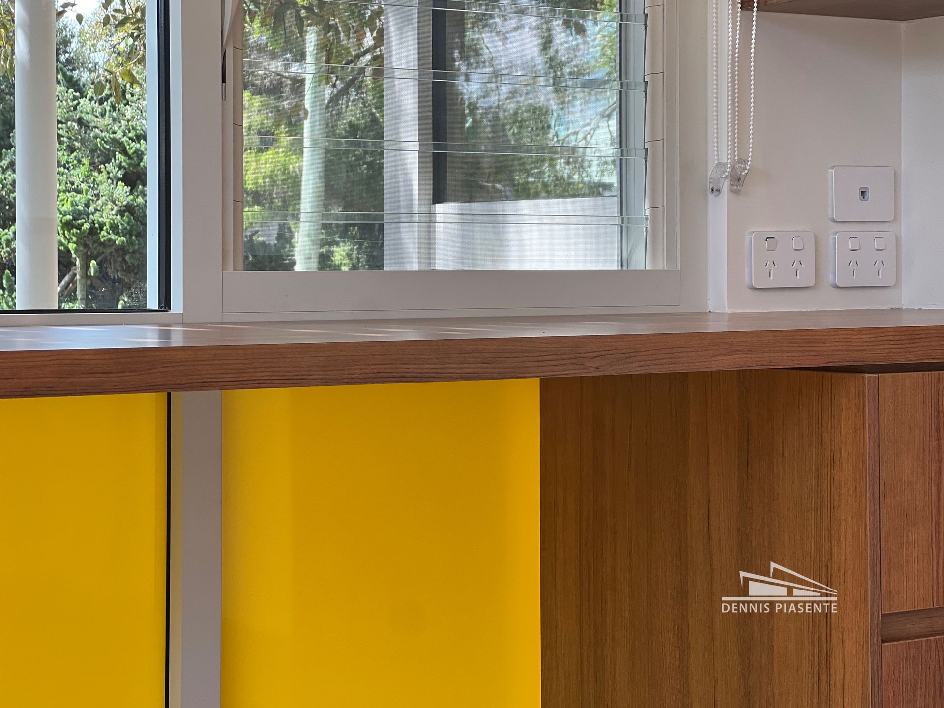 A kitchen with yellow cabinets and a wooden counter top.