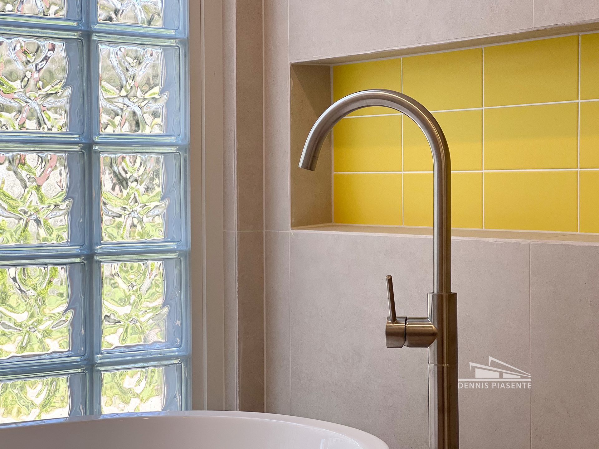 A bathroom with yellow tiles and a bathtub