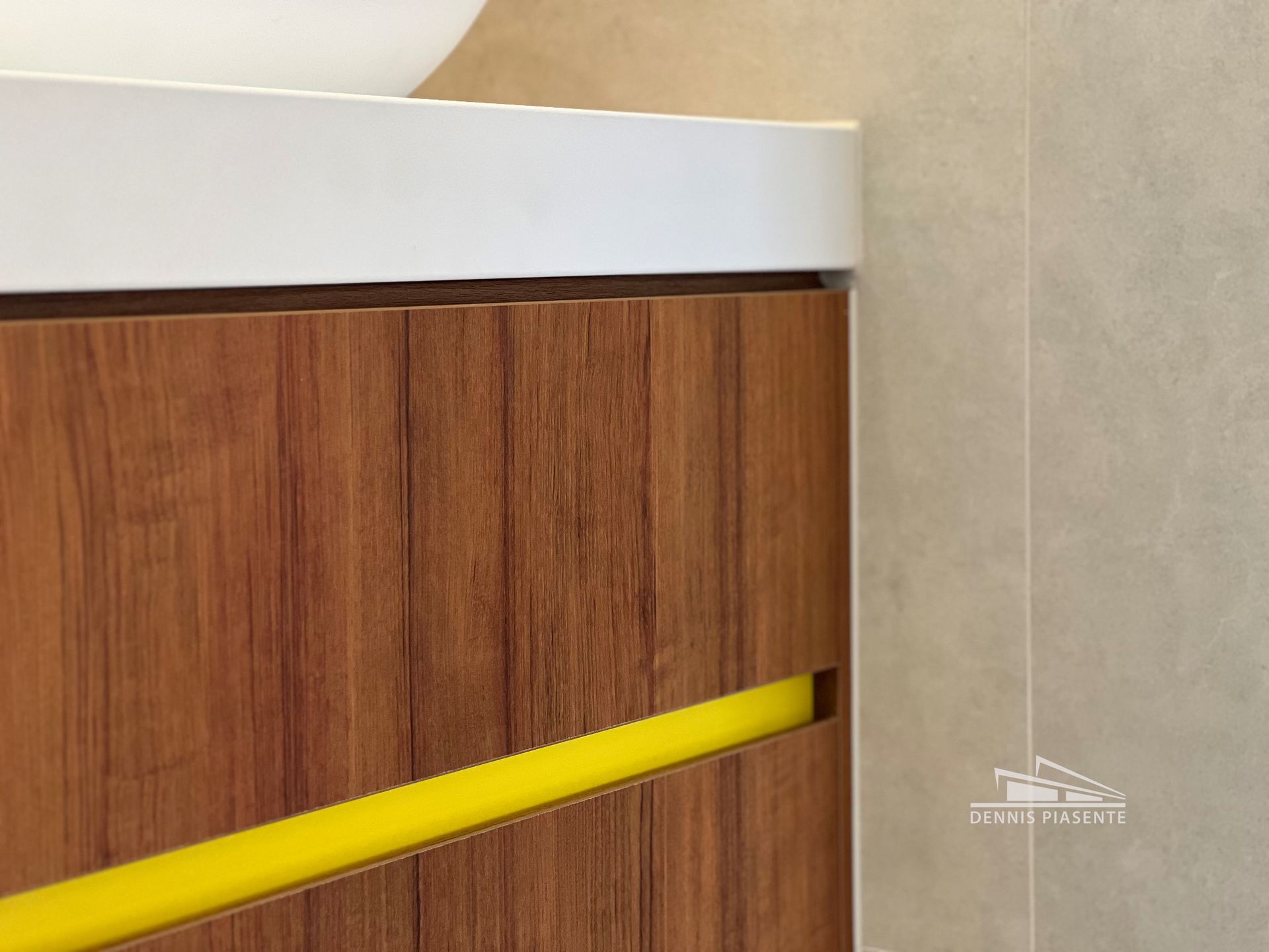 A bathroom vanity with a yellow handle and a sink.