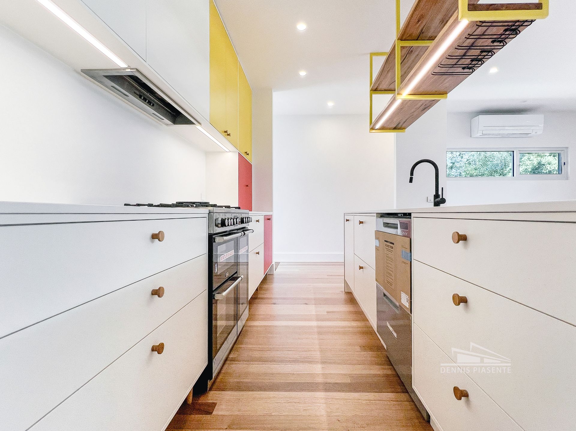 A kitchen with white cabinets , stainless steel appliances , and wooden floors.