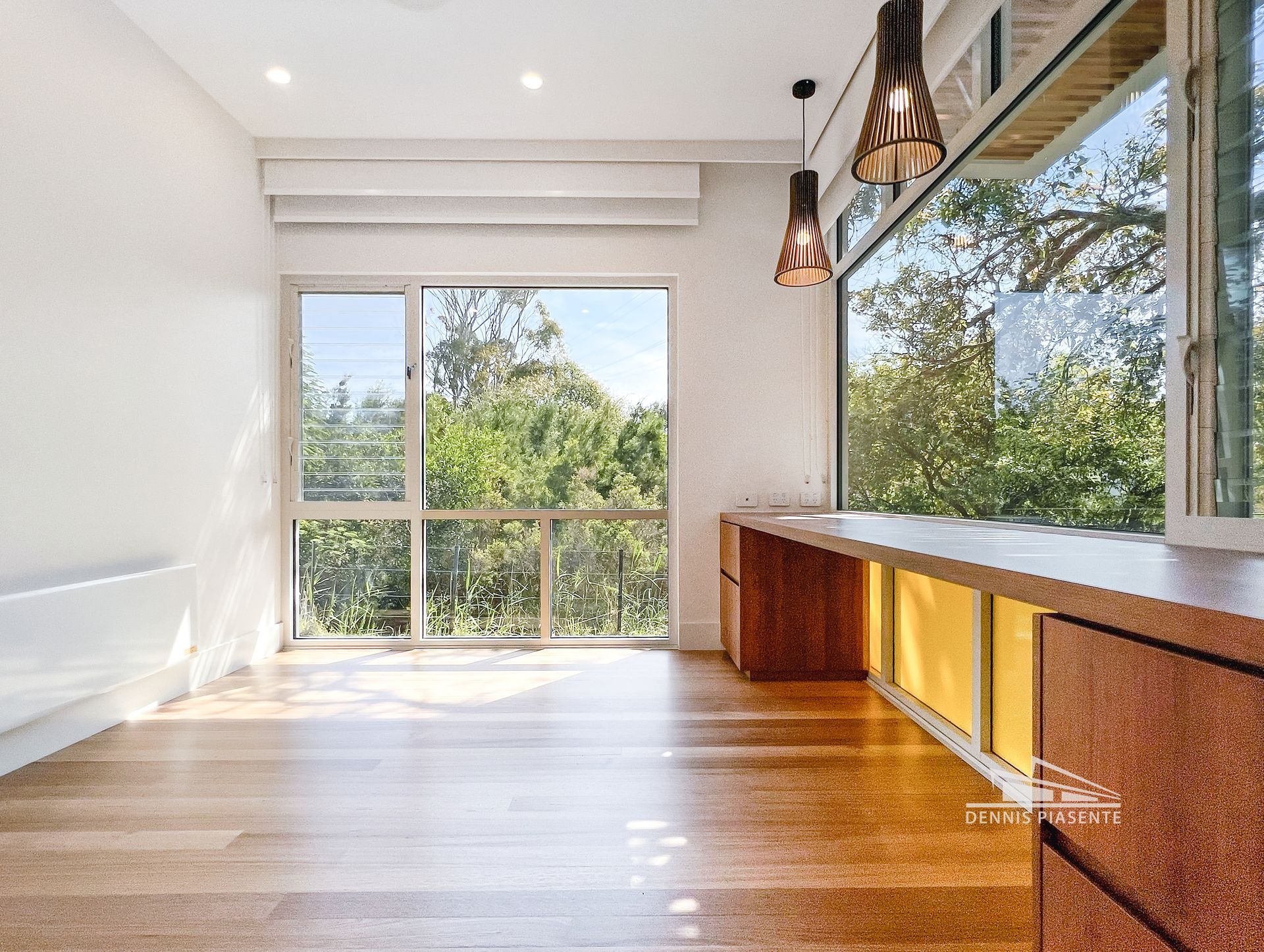 A living room with hardwood floors and a large window.