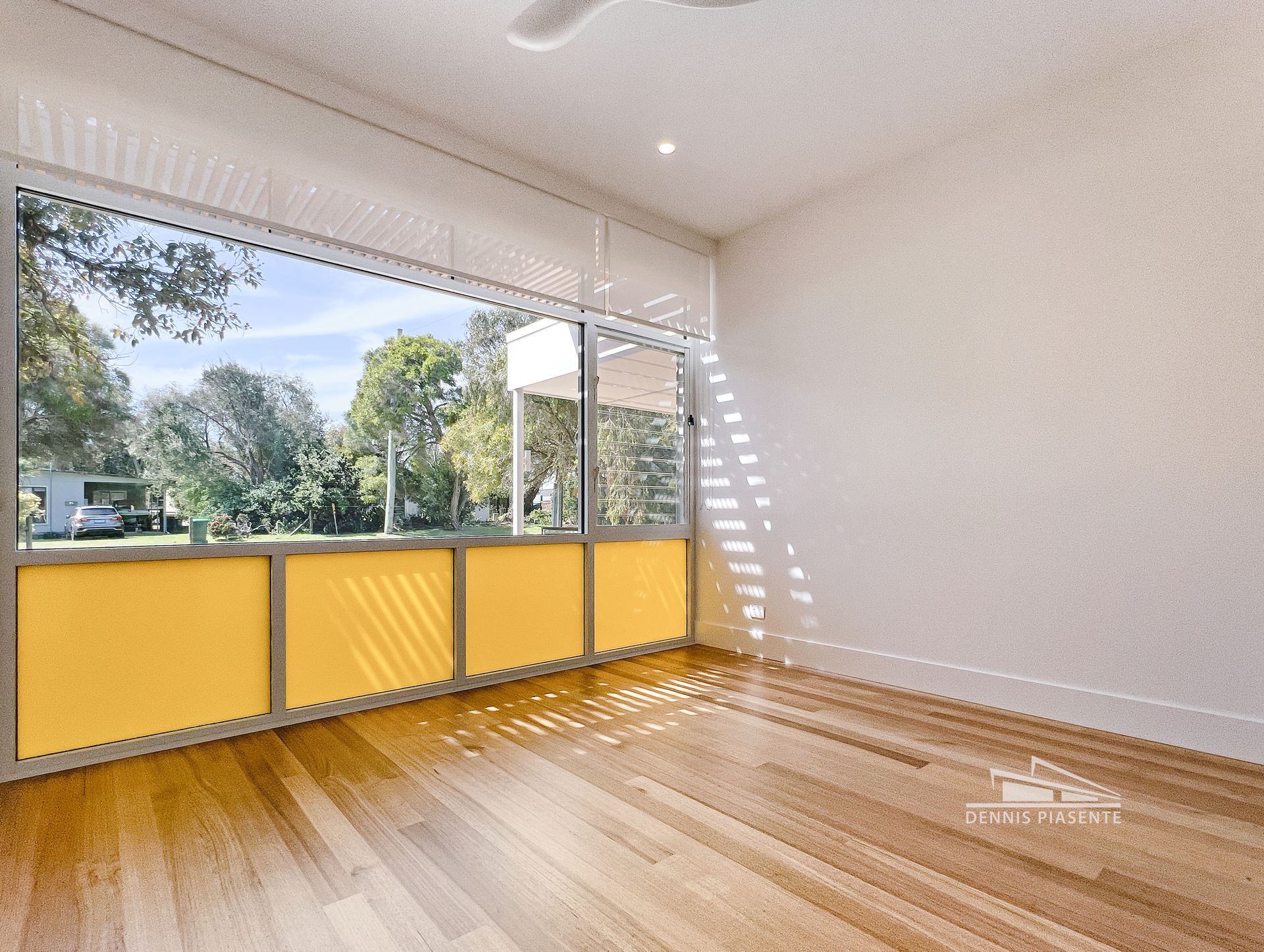 An empty room with hardwood floors and a large window