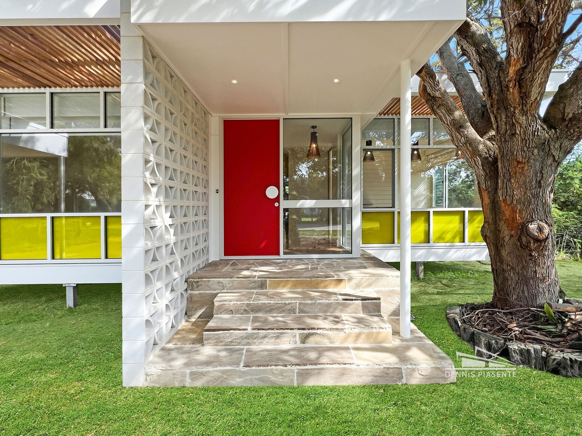 A white house with a red door and yellow windows
