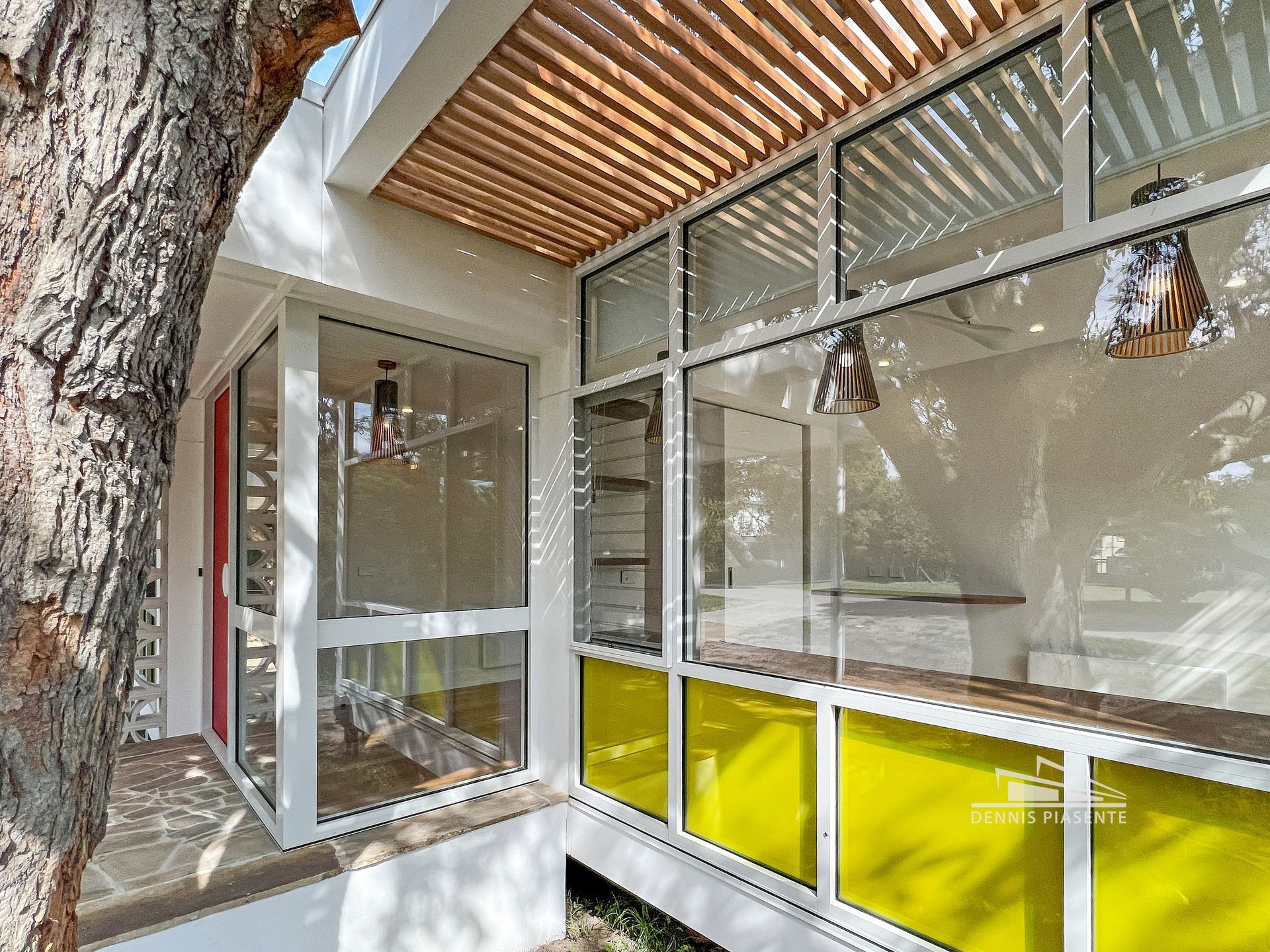 A house with a lot of windows and a tree in the background.