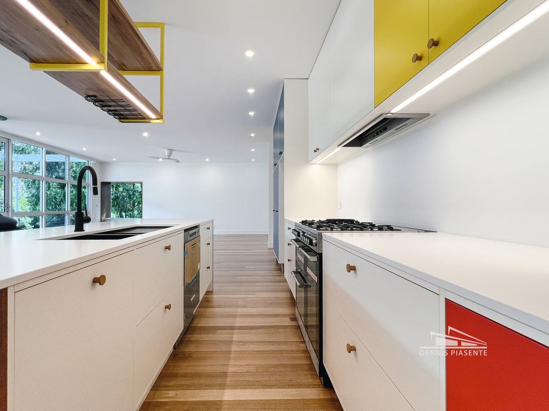 A kitchen with white cabinets , yellow cabinets , and red cabinets.