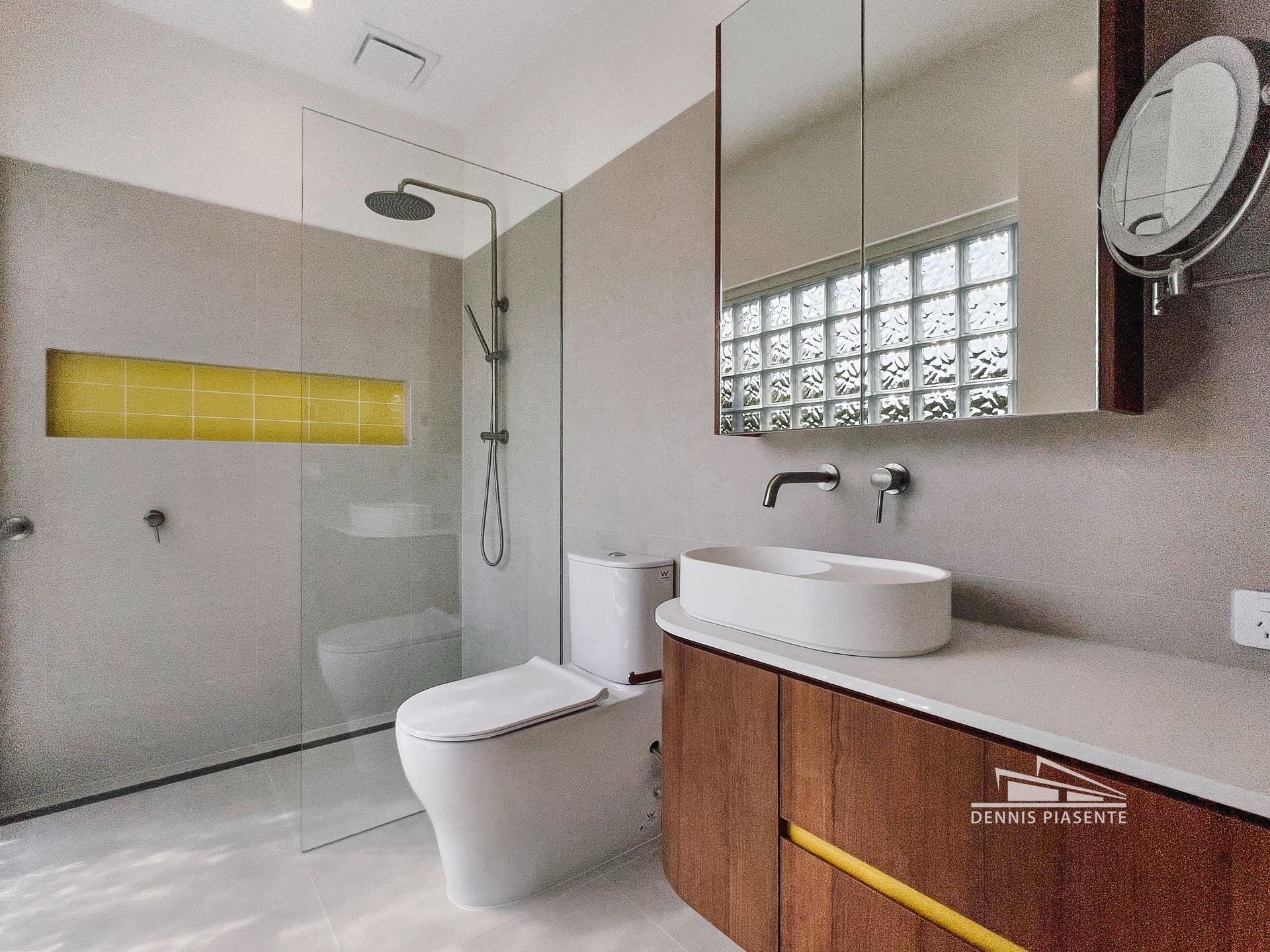 A bathroom with a toilet , sink and shower.