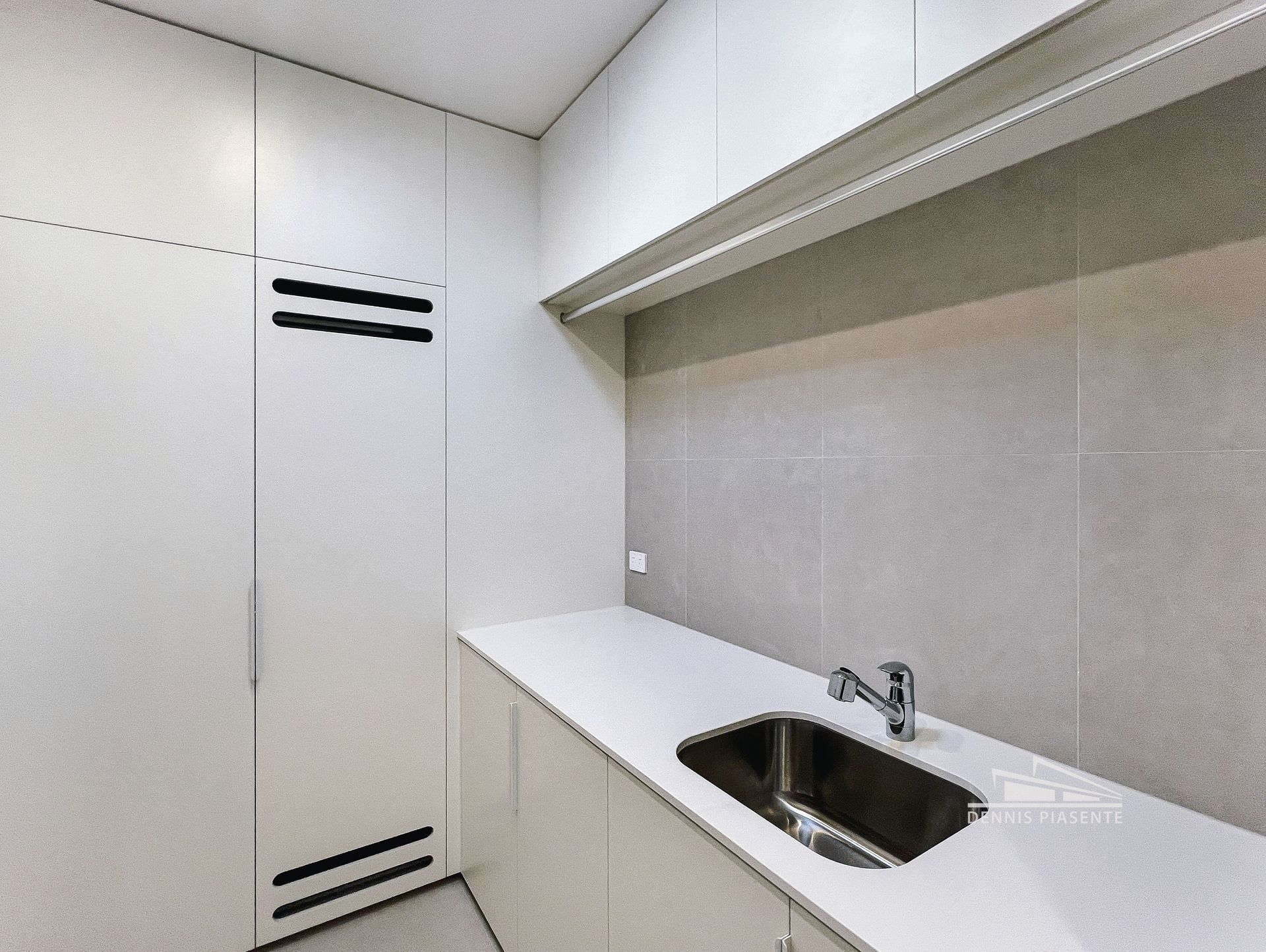 A kitchen with white cabinets and a stainless steel sink
