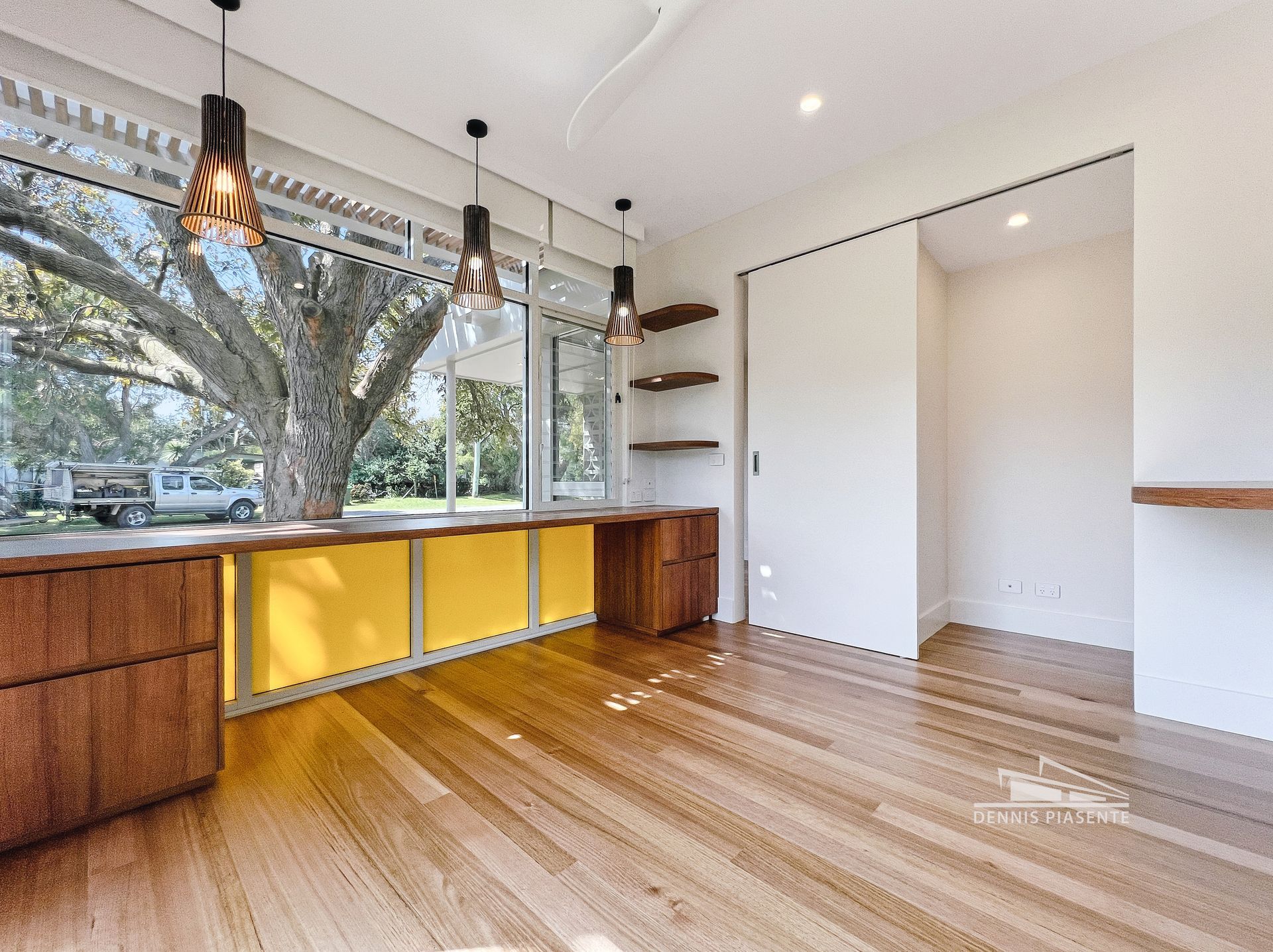 An empty room with hardwood floors and a large window.