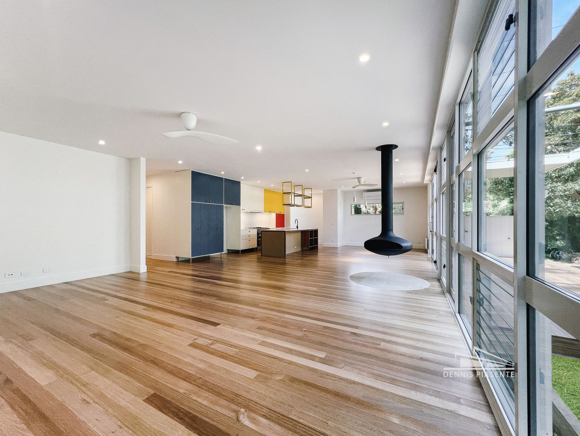 A large empty room with hardwood floors and lots of windows