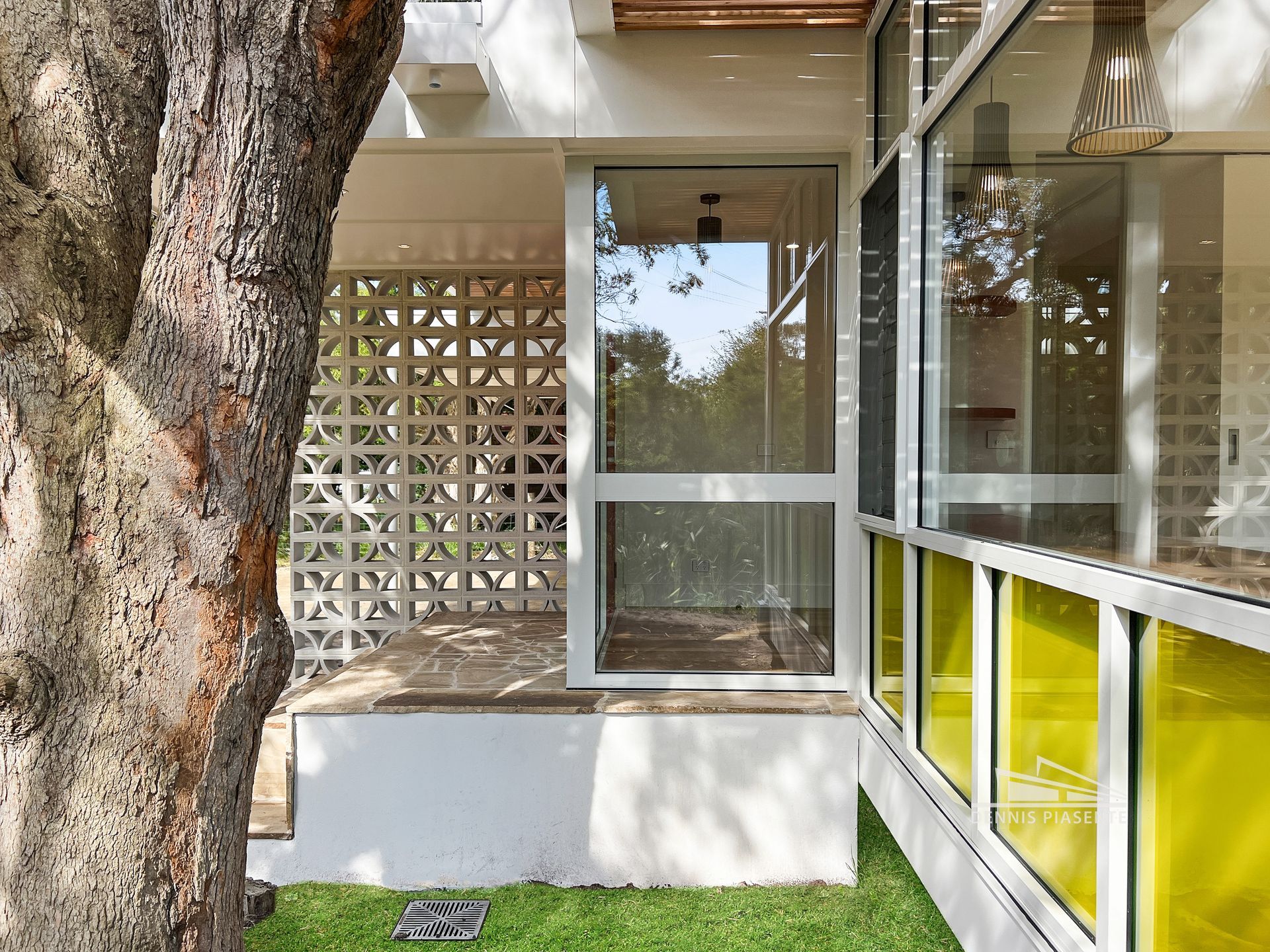 A house with a tree in front of it and a large window
