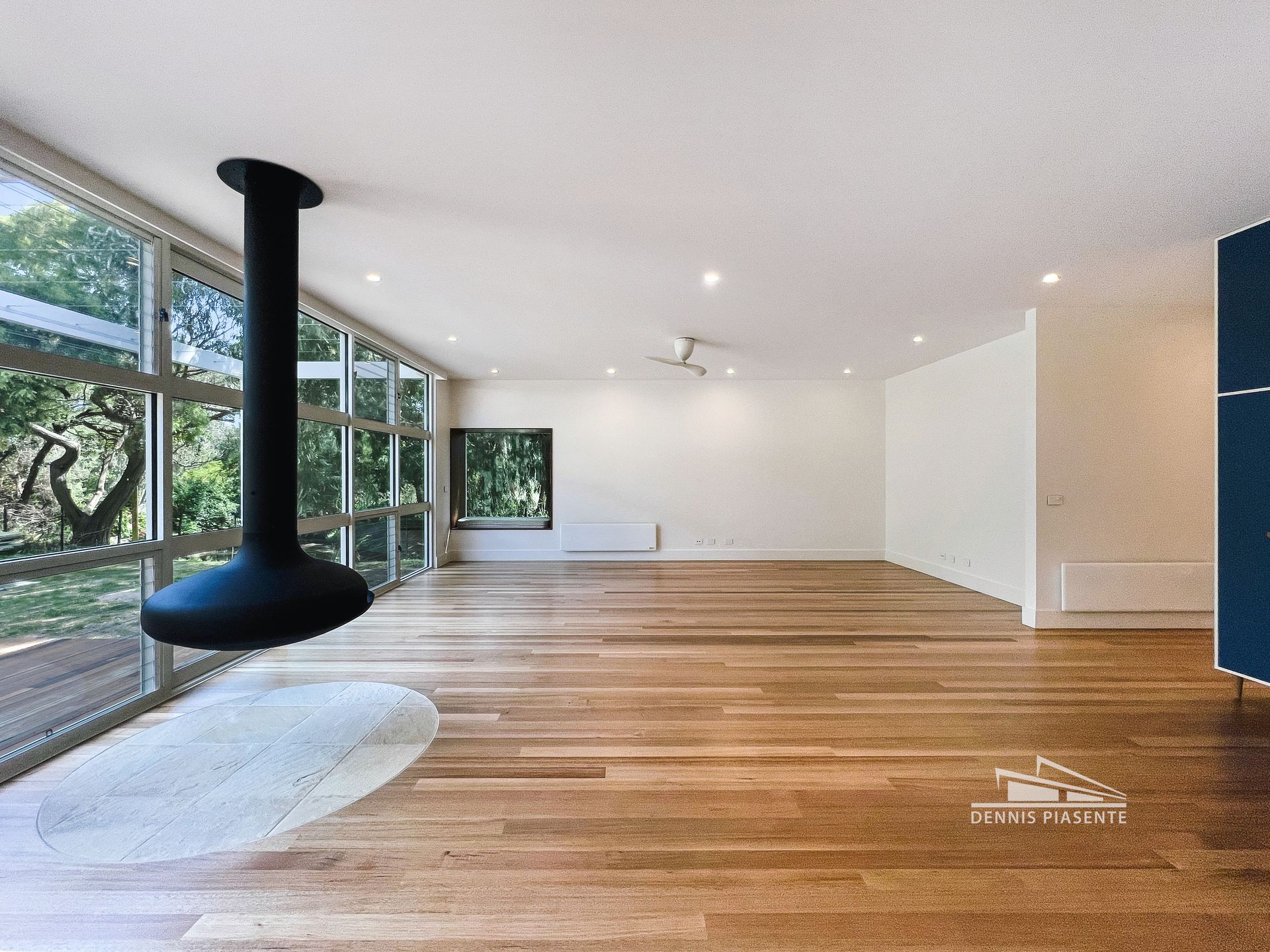 An empty room with a fireplace hanging from the ceiling