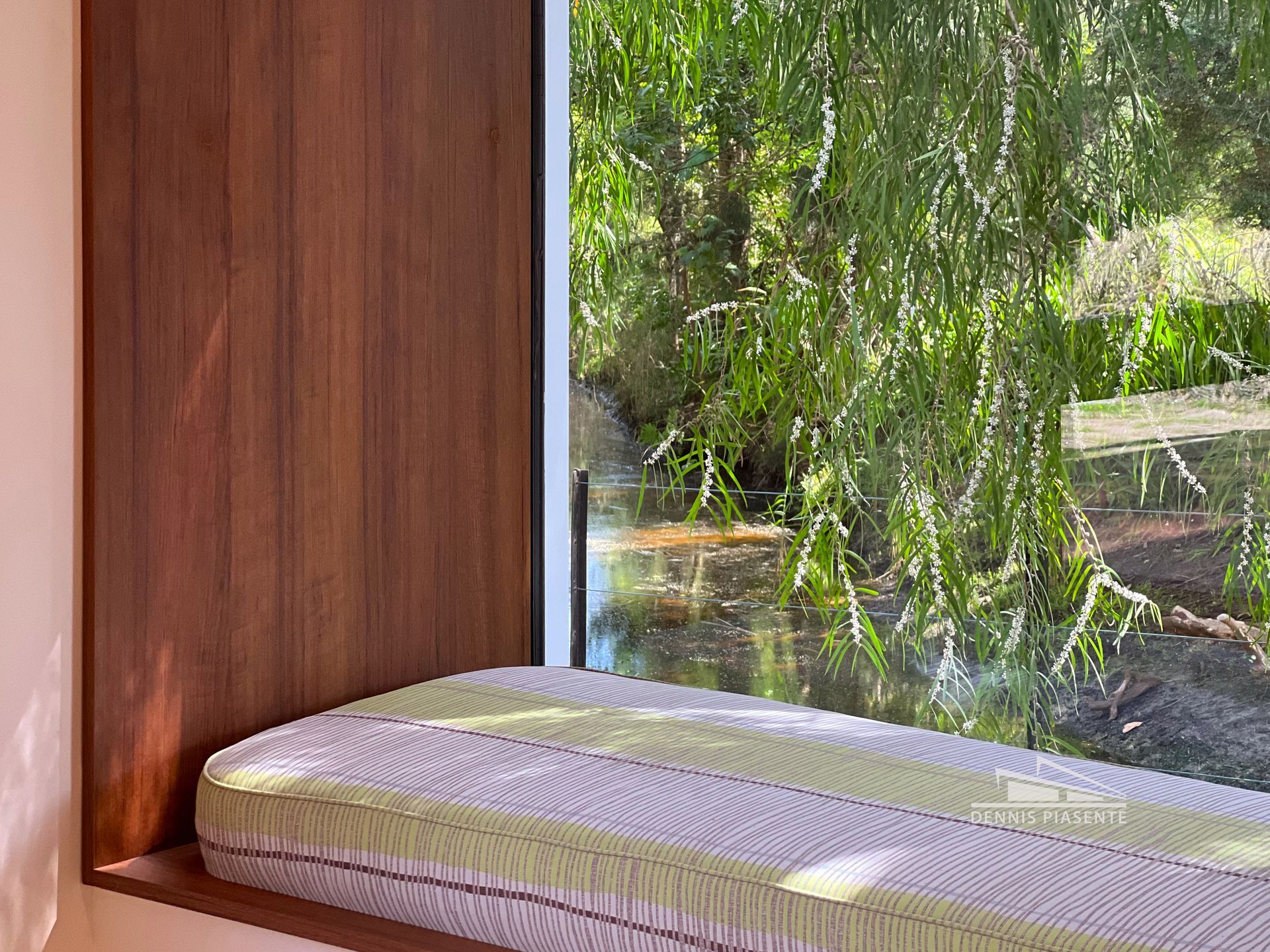 A window seat with a view of a river and trees.