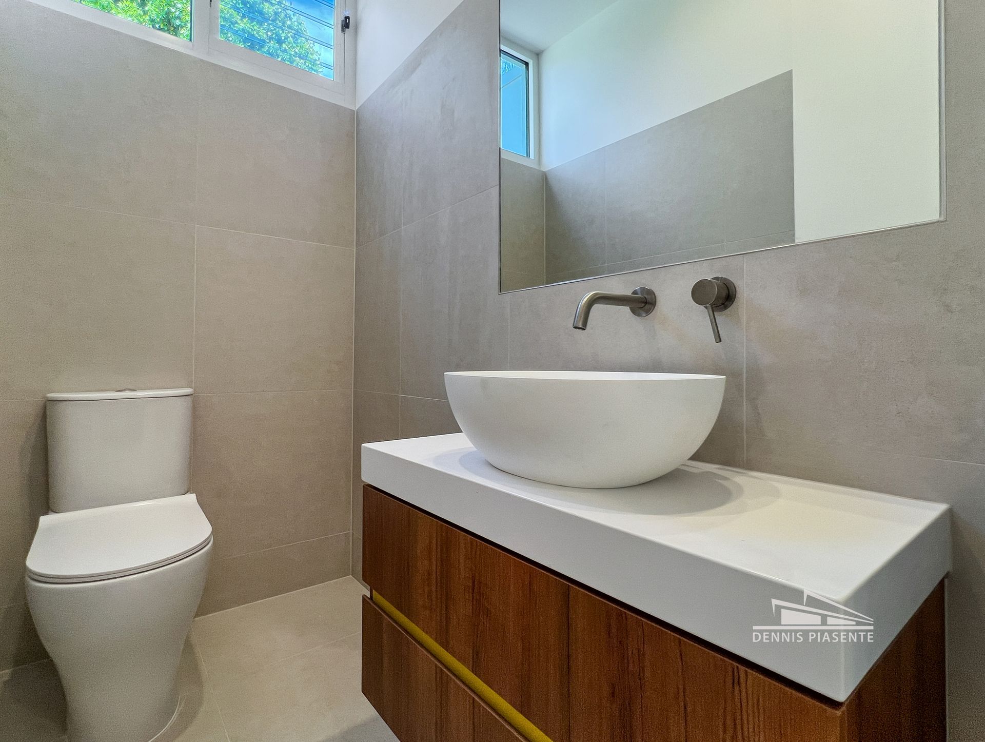 A bathroom with a toilet , sink and mirror.