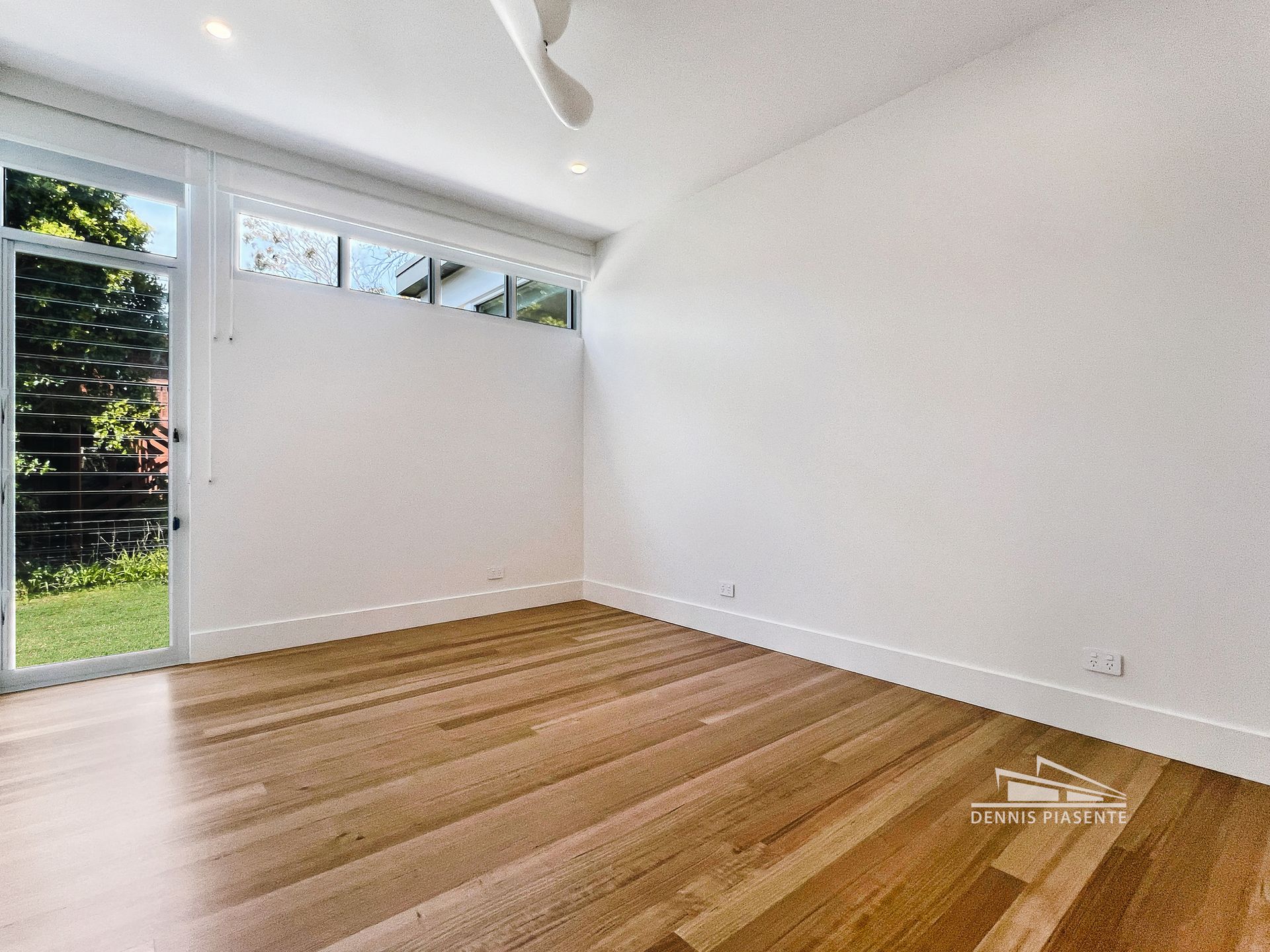 An empty room with hardwood floors and white walls