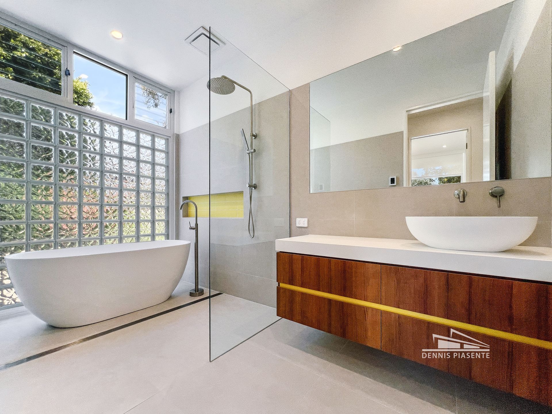 A bathroom with a tub , sink , mirror and shower.