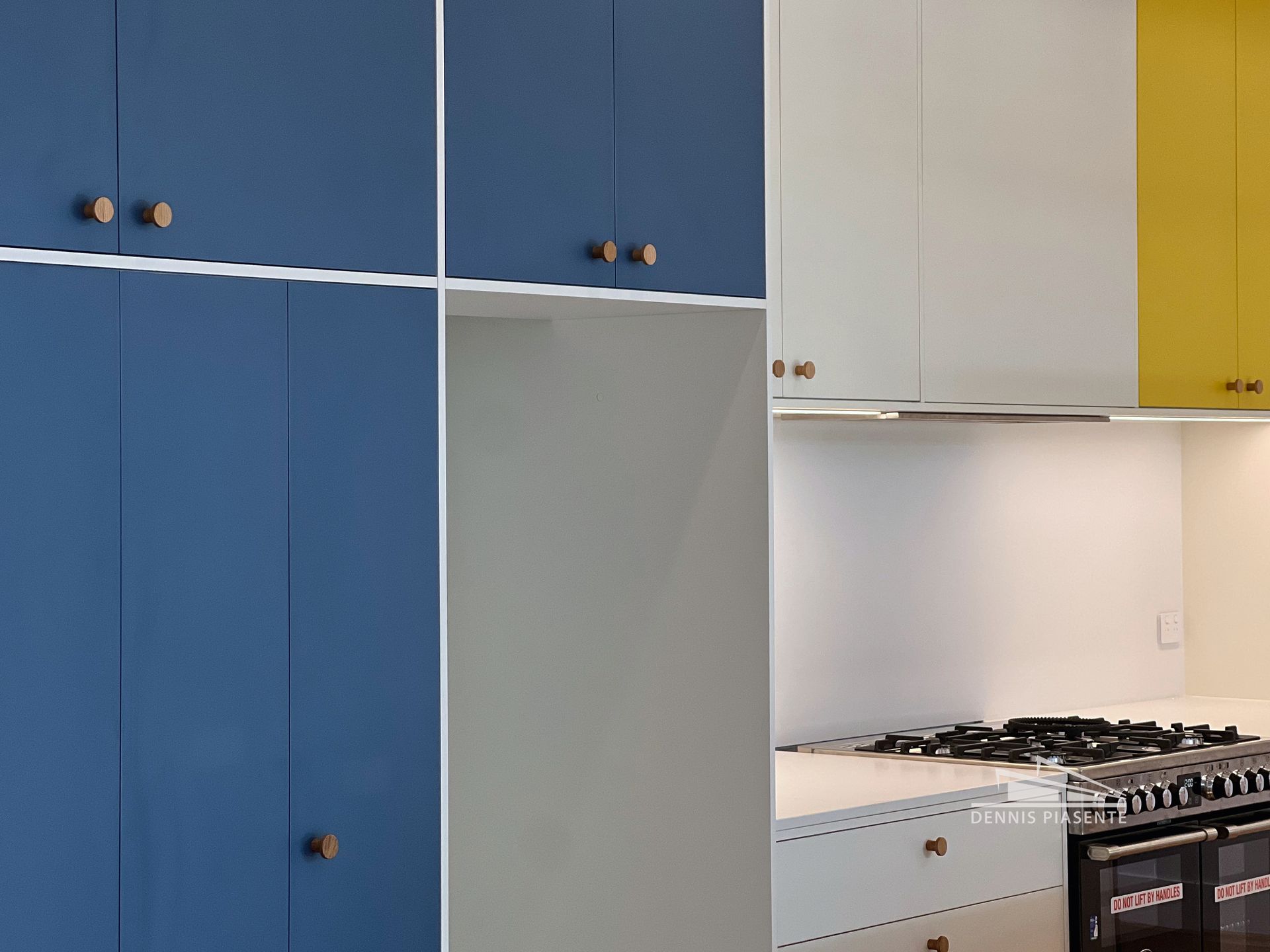 A kitchen with blue and yellow cabinets and a stove