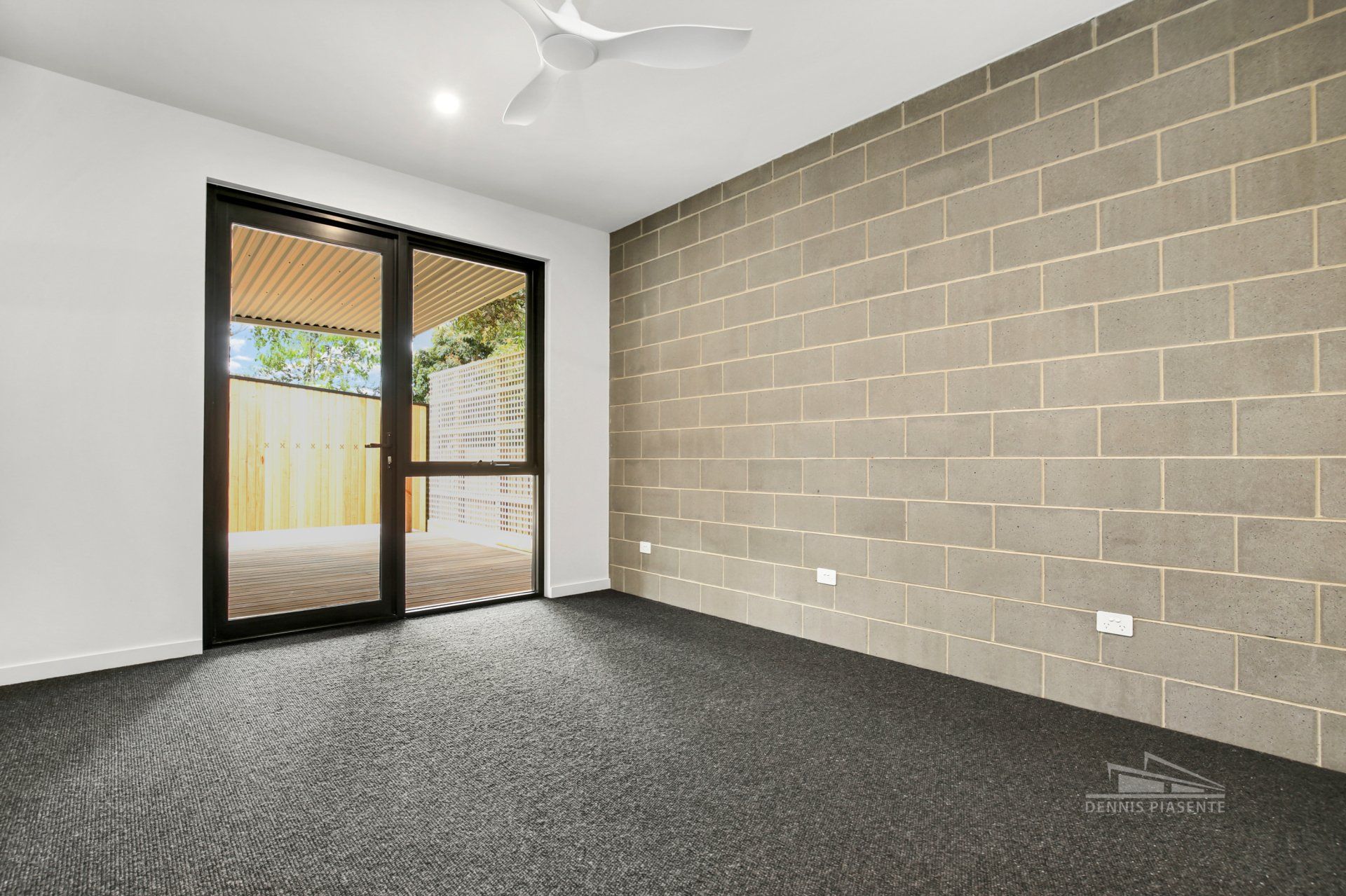 An empty room with a brick wall and a sliding glass door.