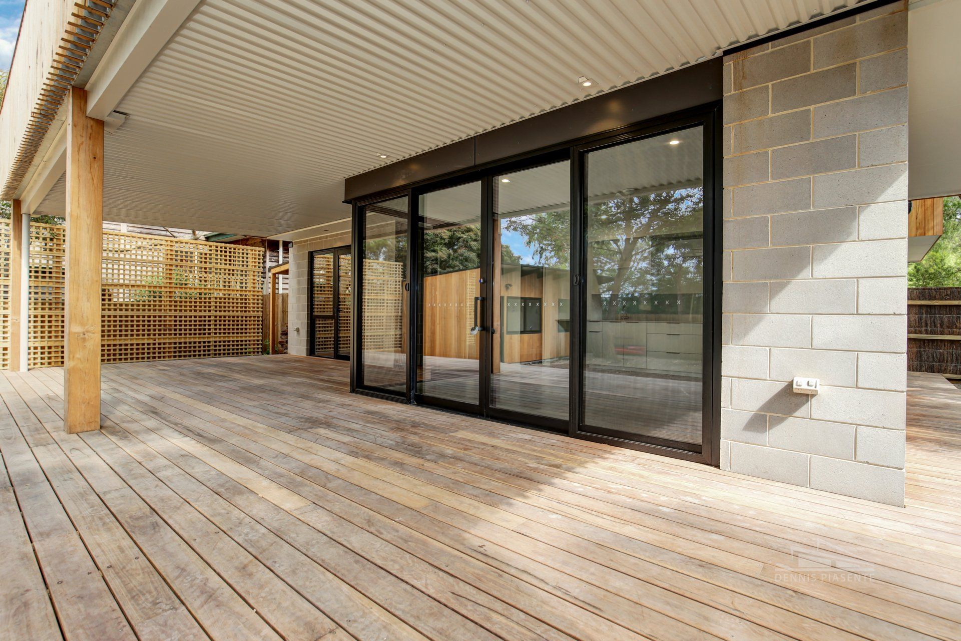 A large patio with a wooden deck and sliding glass doors.