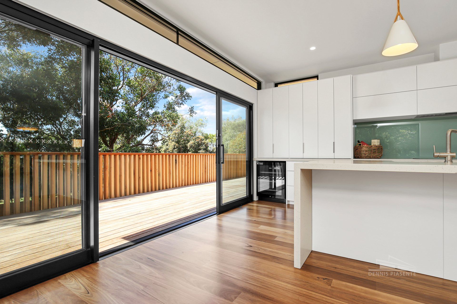 An empty kitchen with sliding glass doors leading to a deck.