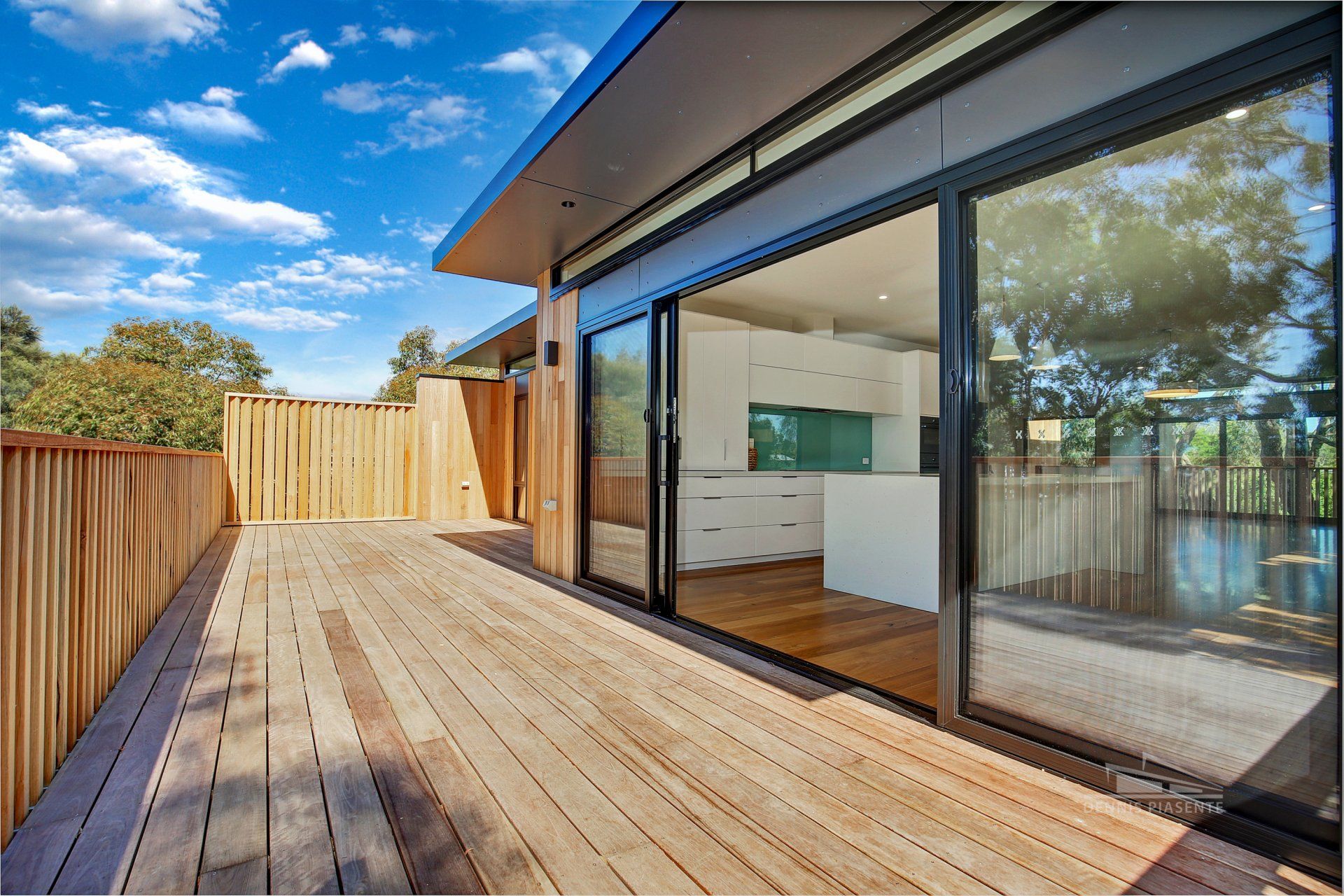 A house with a wooden deck and sliding glass doors