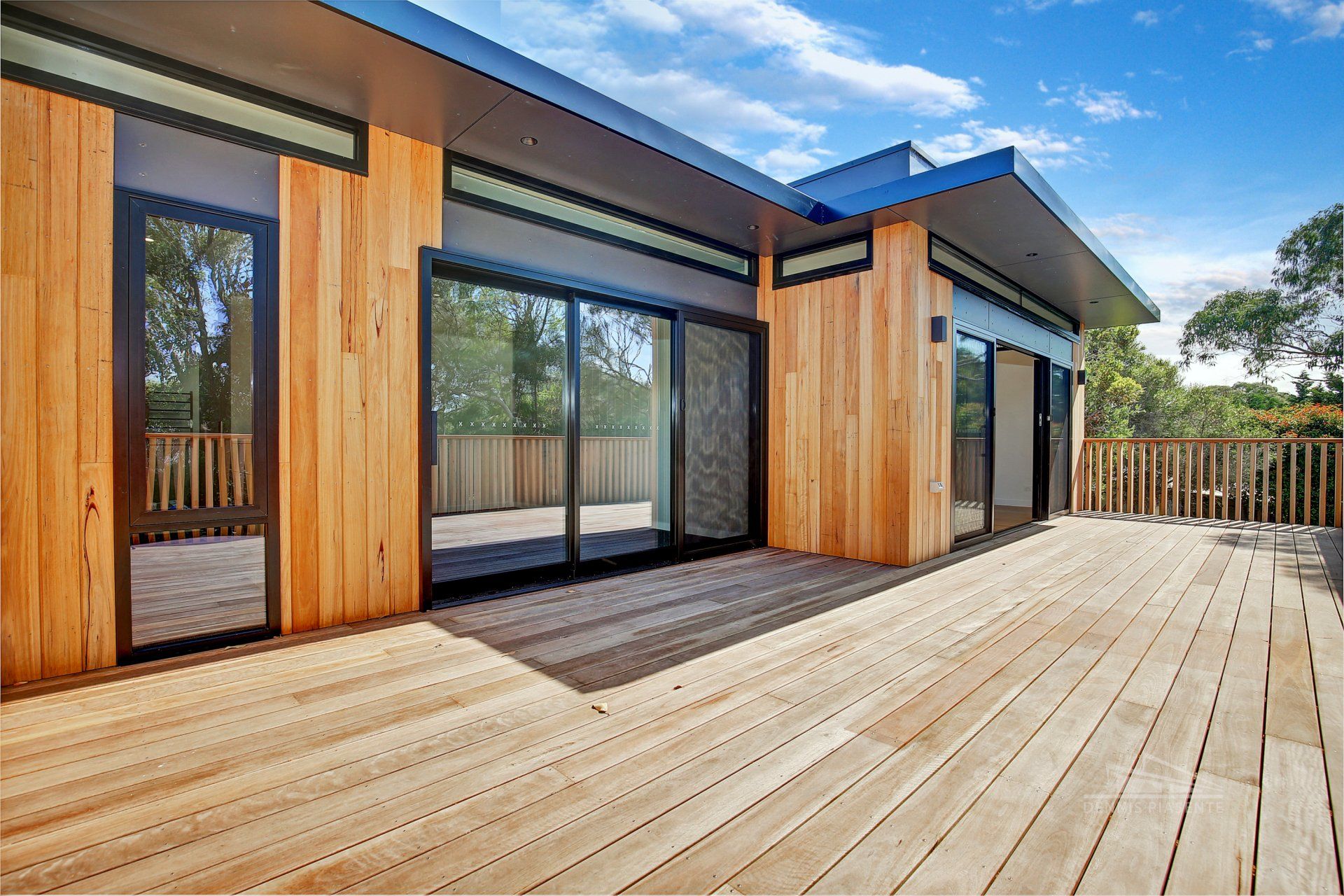 A house with a large wooden deck in front of it