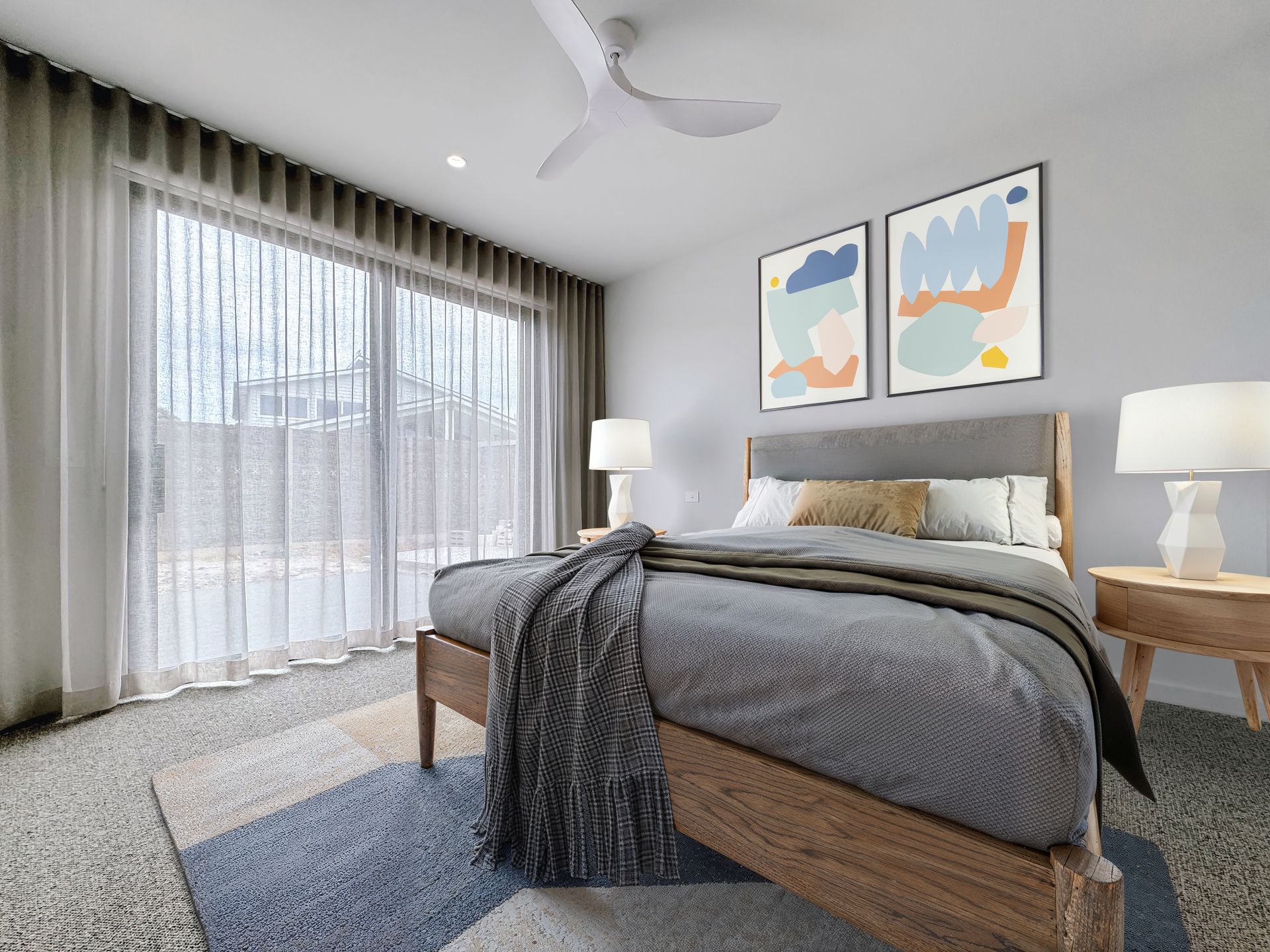 A bedroom with a large bed and a ceiling fan.