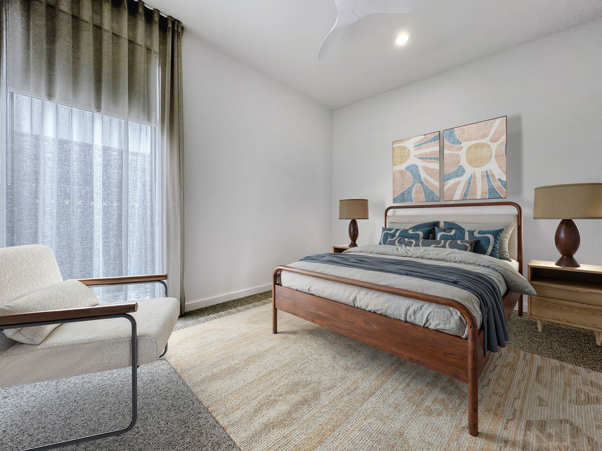 A bedroom with a bed , chair , lamps and a large window.