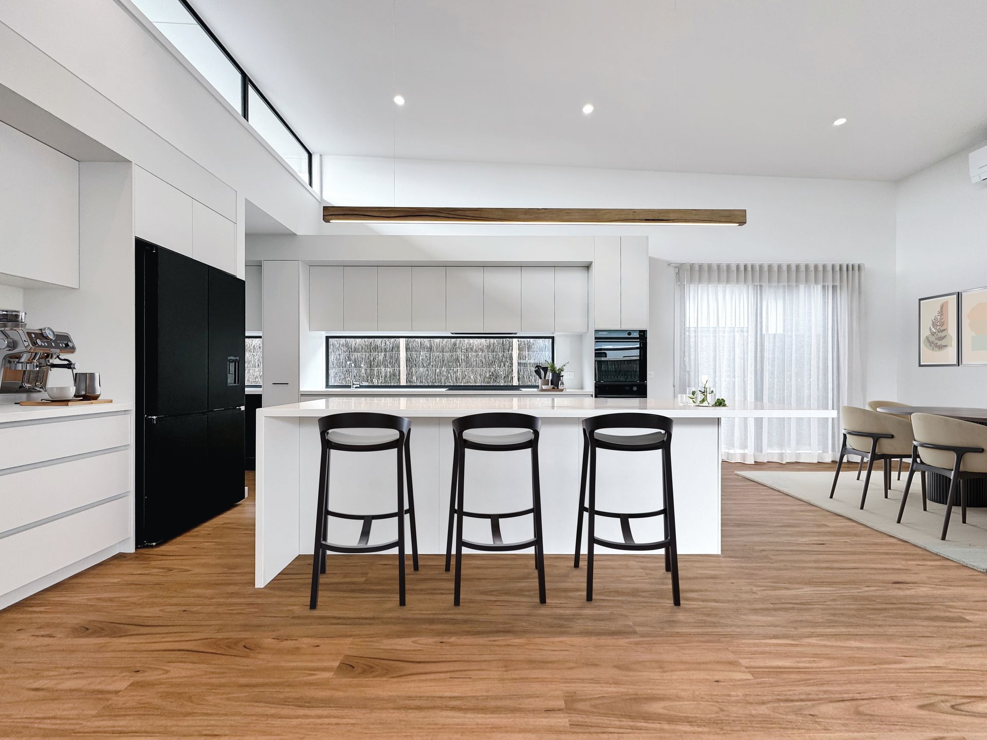 A kitchen with a large island and three bar stools.