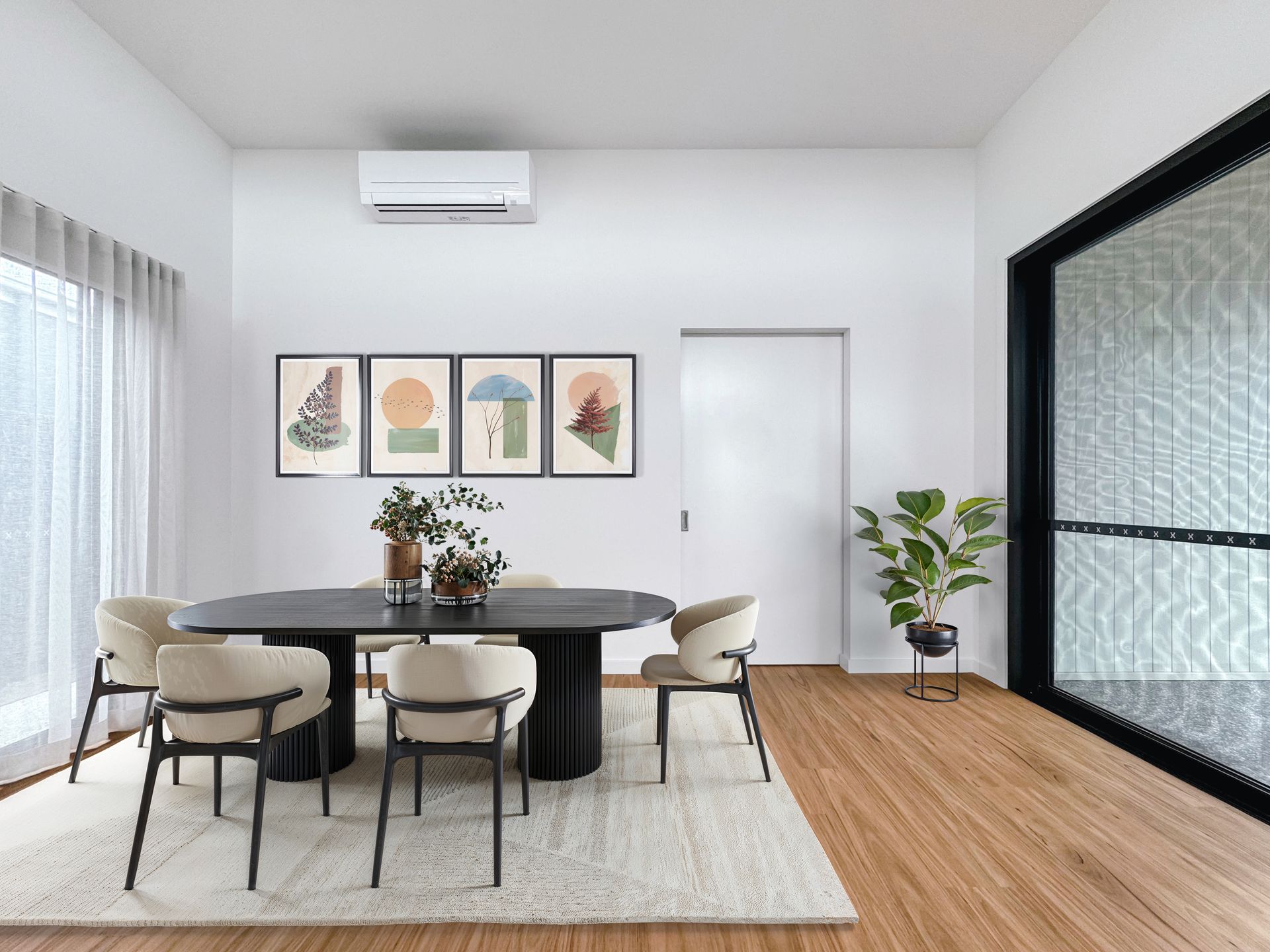A dining room with a table and chairs and a plant.