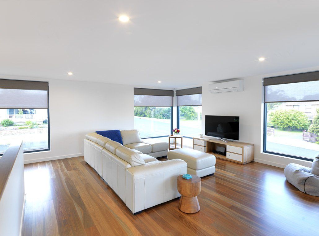 A living room with a white couch and a flat screen tv