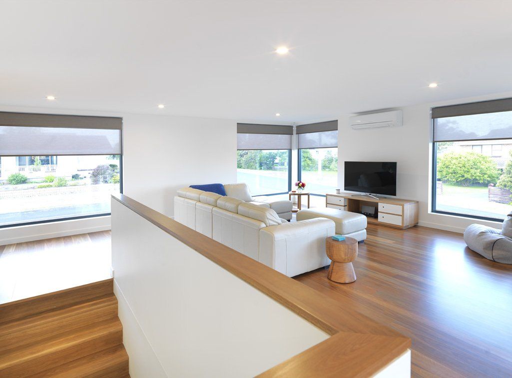 A living room with a white couch and a flat screen tv