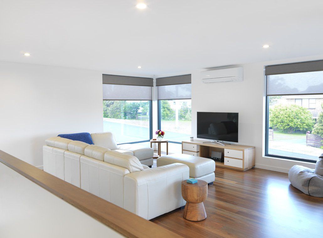 A living room with a white couch and a flat screen tv