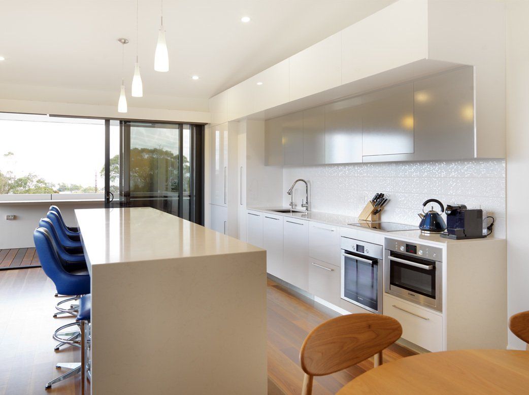 A kitchen with white cabinets and stainless steel appliances
