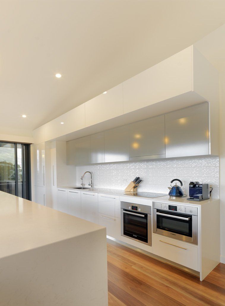 A kitchen with white cabinets and stainless steel appliances