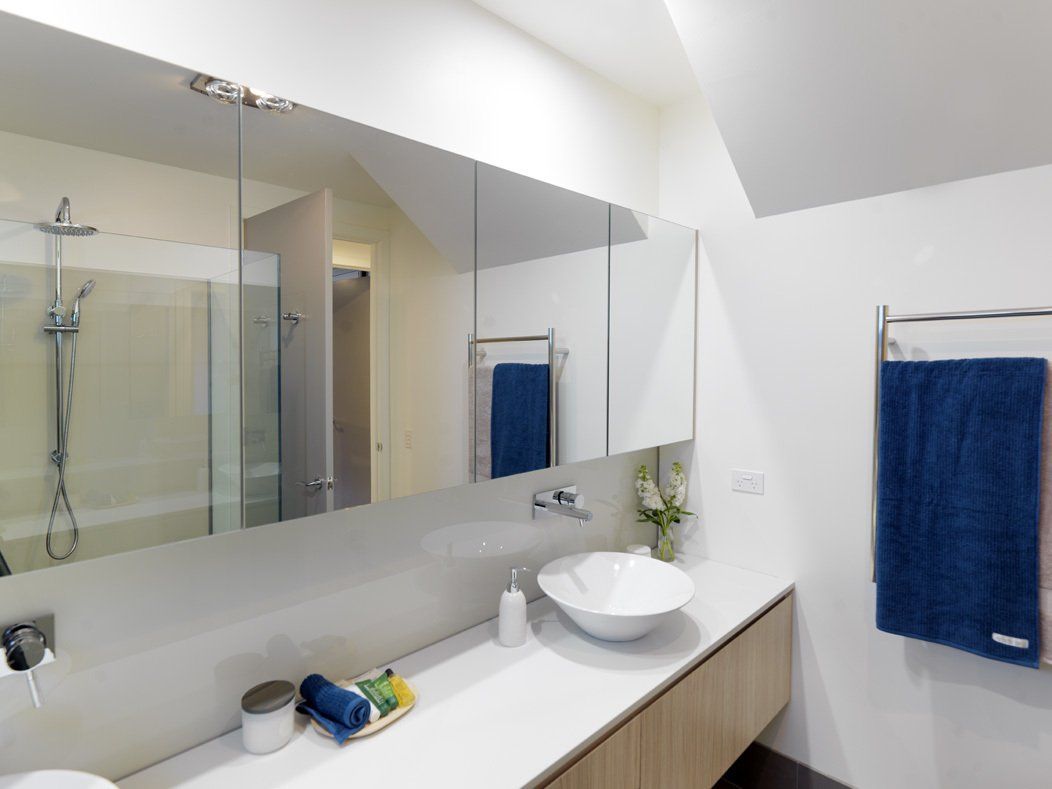 A bathroom with a sink and a large mirror