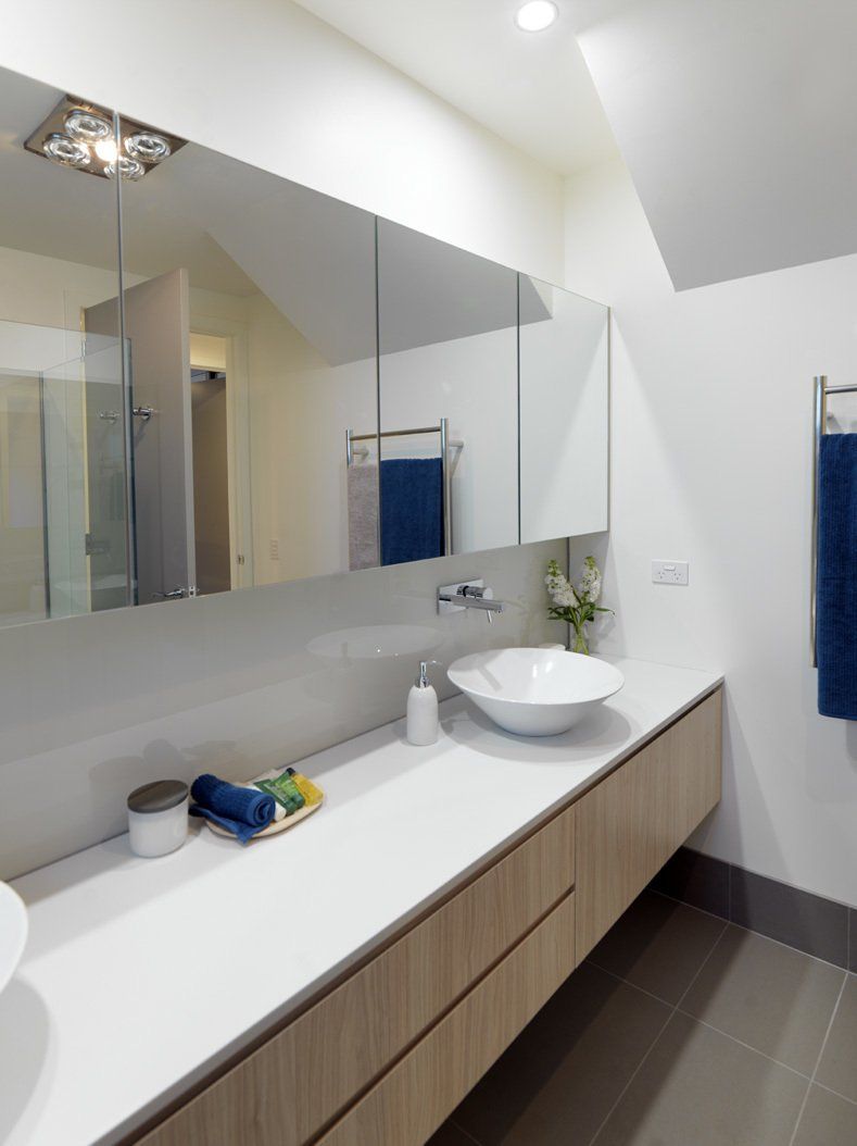 A bathroom with two sinks and a large mirror