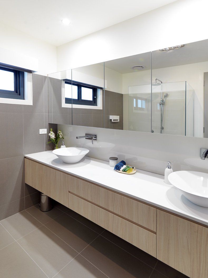 A bathroom with two sinks and a large mirror.
